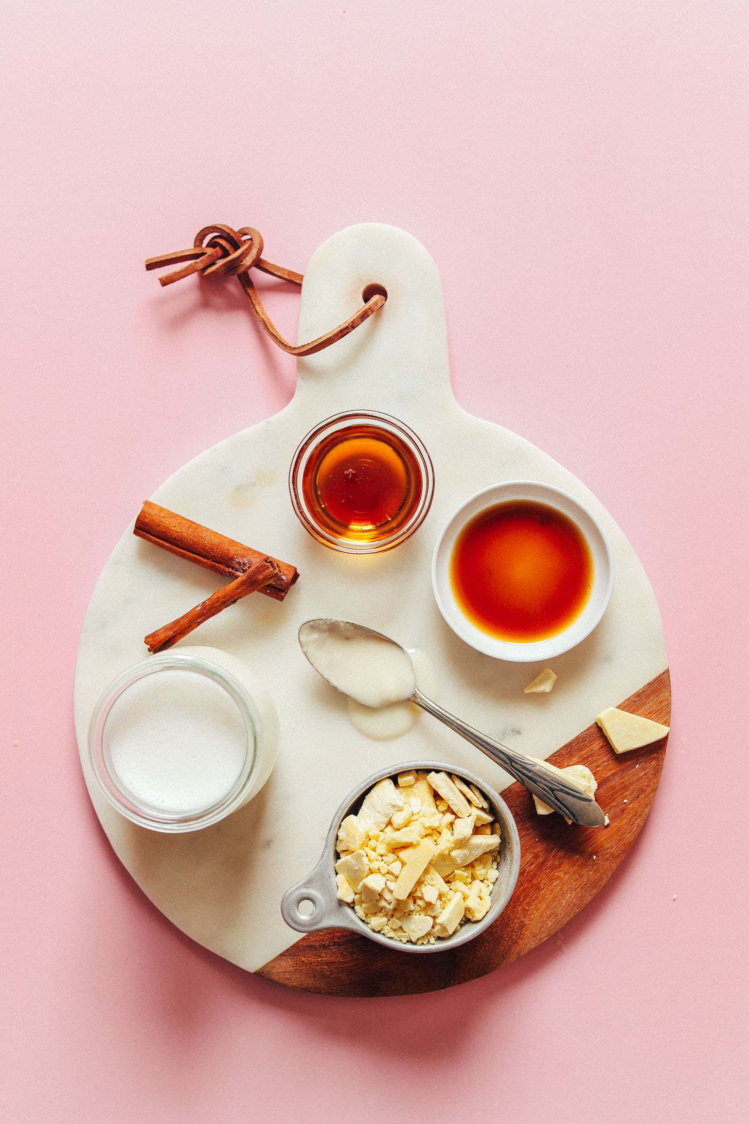 Marble cutting board with coconut milk, cacao butter, maple syrup, cinnamon, and vanilla for making homemade Vegan White Hot Chocolate