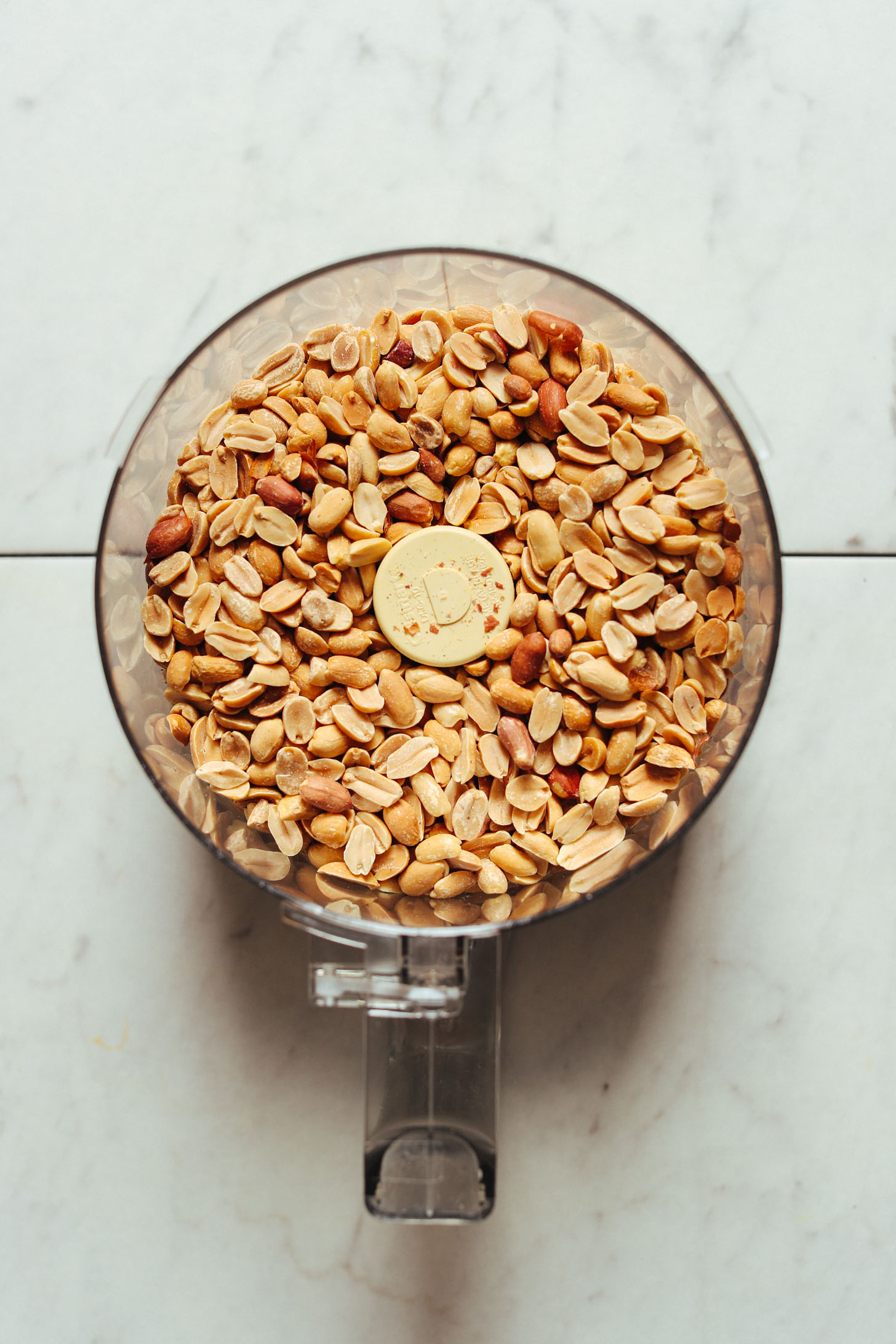 Food processor with peanuts ready to be made into homemade Cinnamon Raising Peanut Butter