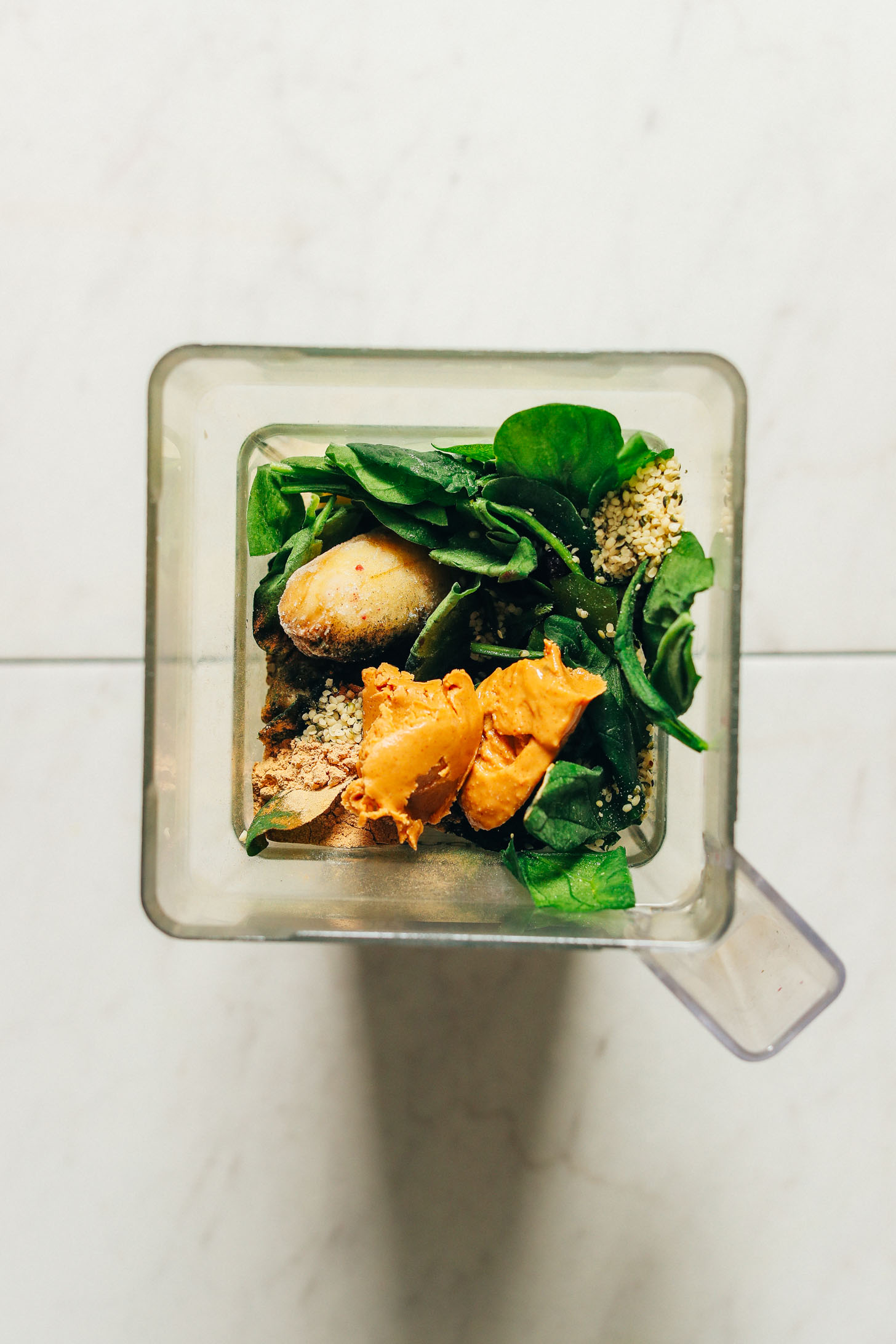 Blender with ingredients for making Peanut Butter Banana Green Smoothie Bowls