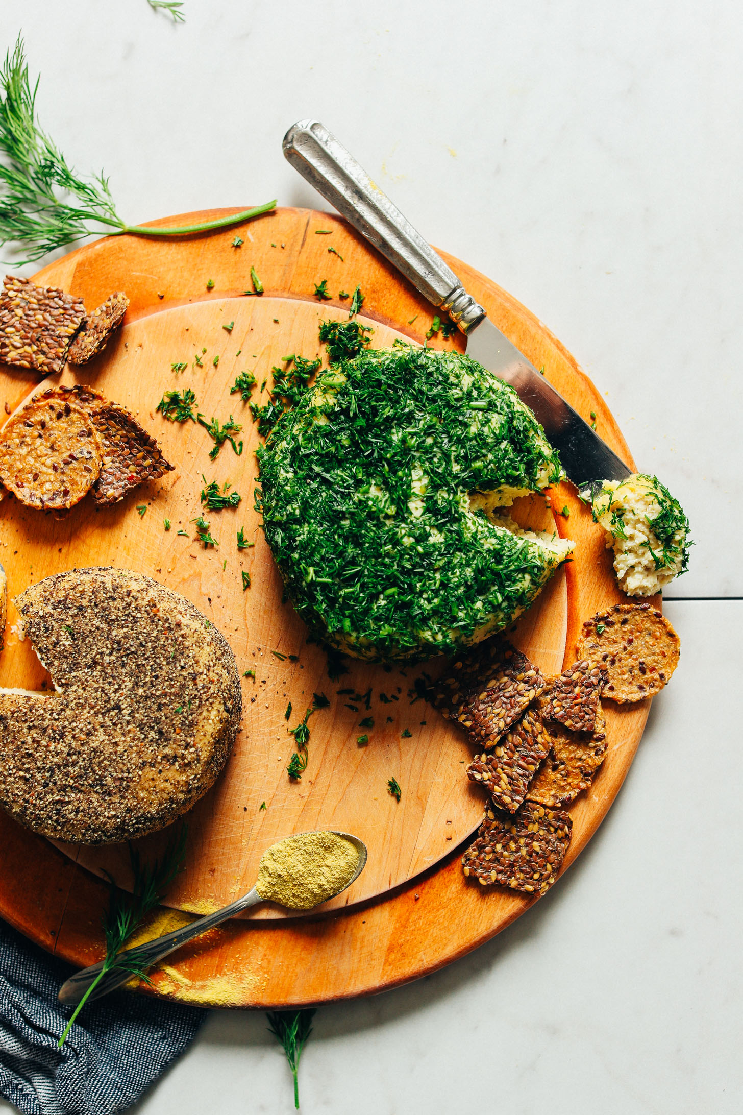 Wood cutting board with gluten-free crackers and Cultured Vegan Cheese made two ways