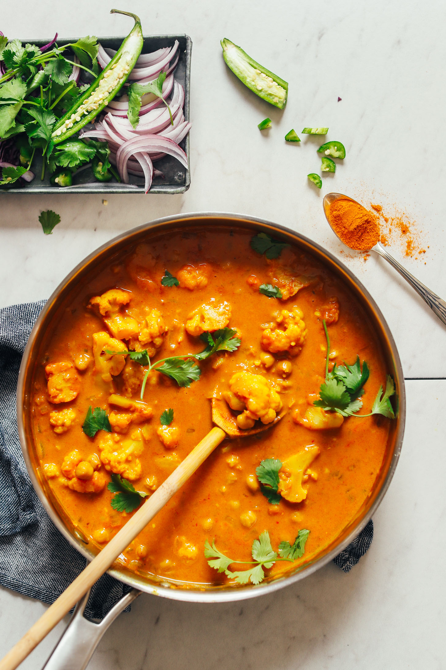 Large pot filled with Yellow Chickpea Cauliflower Curry and sprinkled with cilantro
