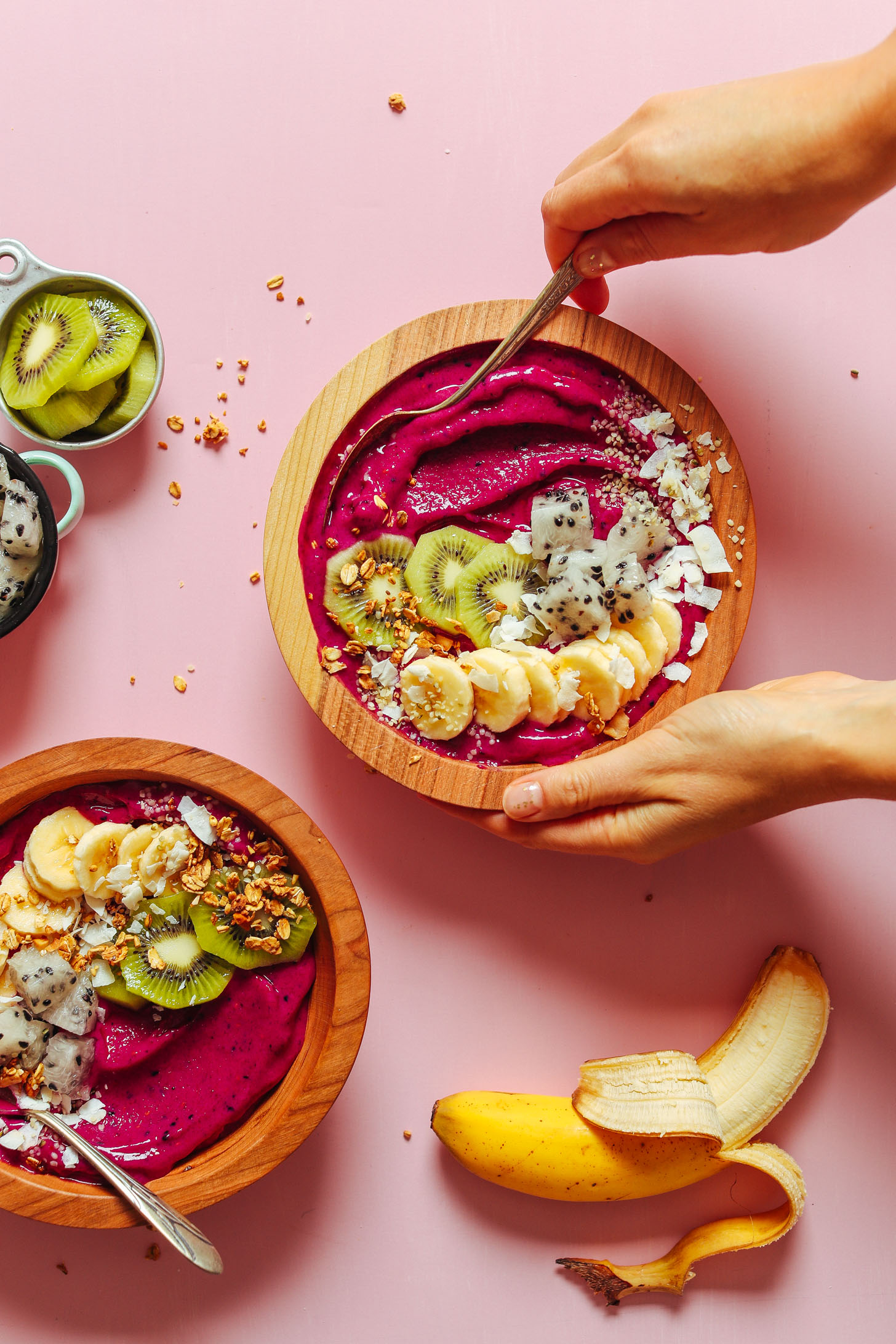 Grabbing a spoonful of our vegan Dragon Fruit Smoothie Bowl topped with fresh fruit, coconut, and granola