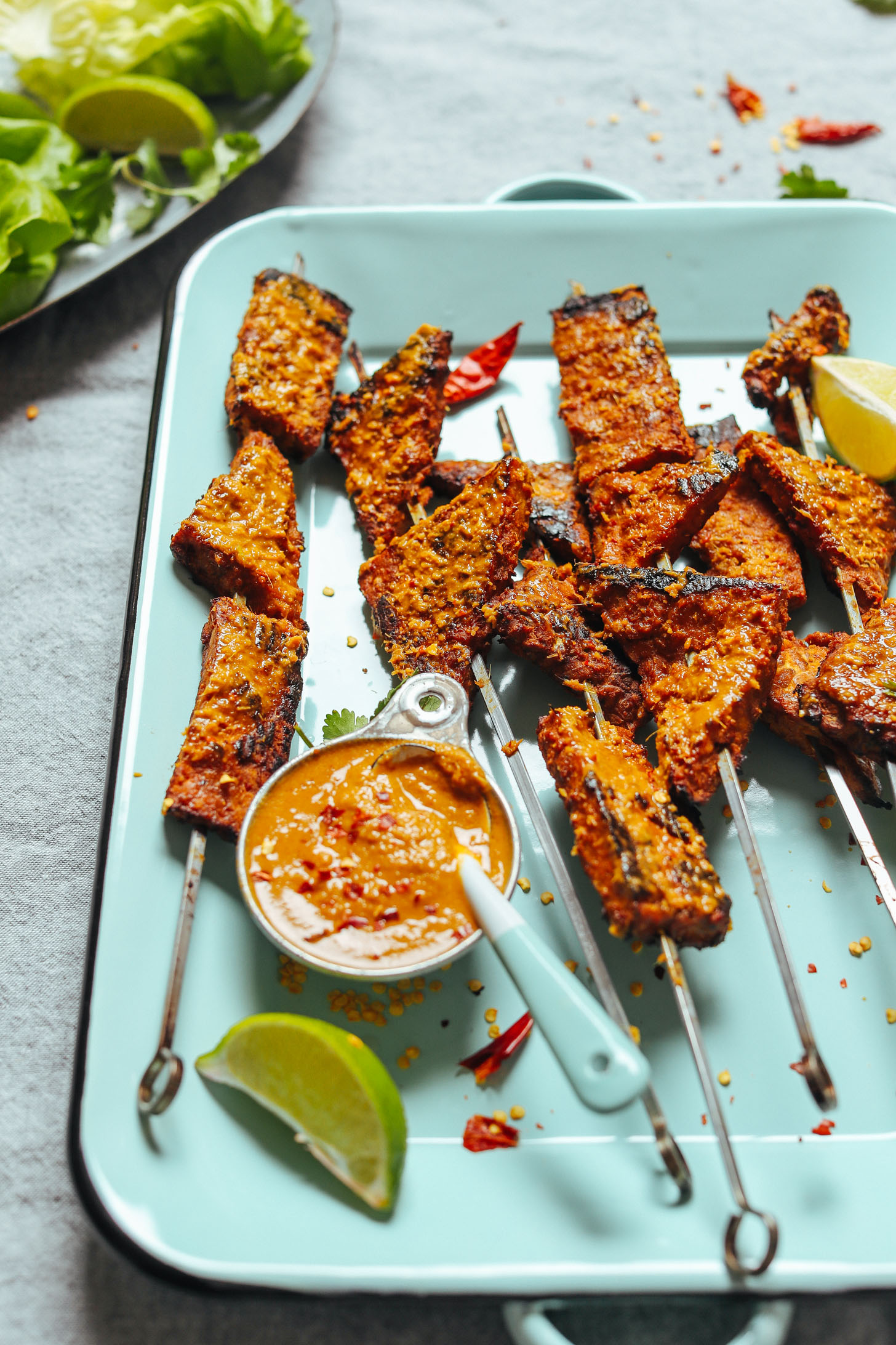 Blue platter with grilled vegan tempeh skewers and lemongrass sauce