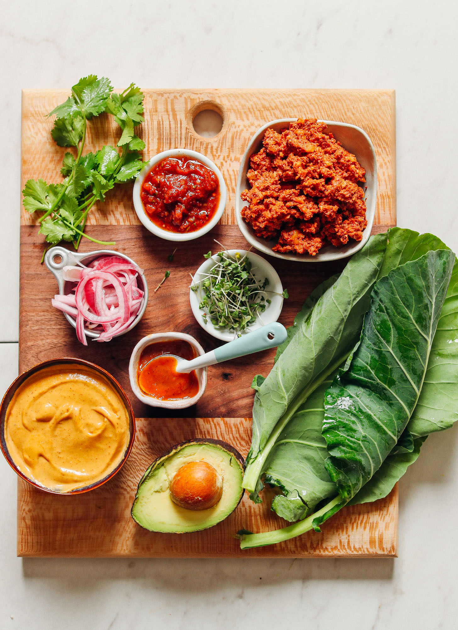 Cutting board with ingredients for making homemade Raw Vegan Collard Green Burritos