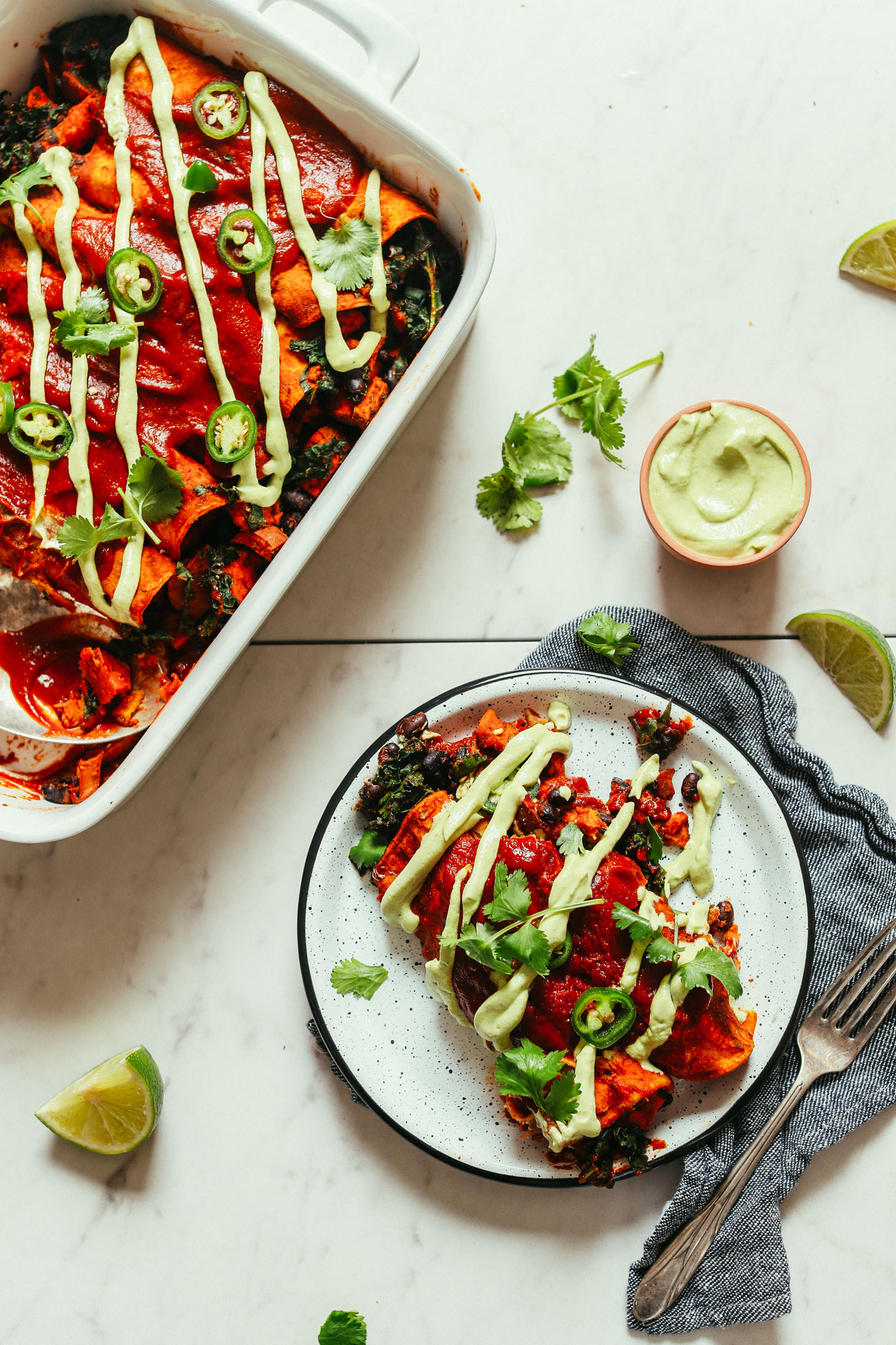Baking pan and plate full of gluten-free vegan Sweet Potato Black Bean Enchiladas