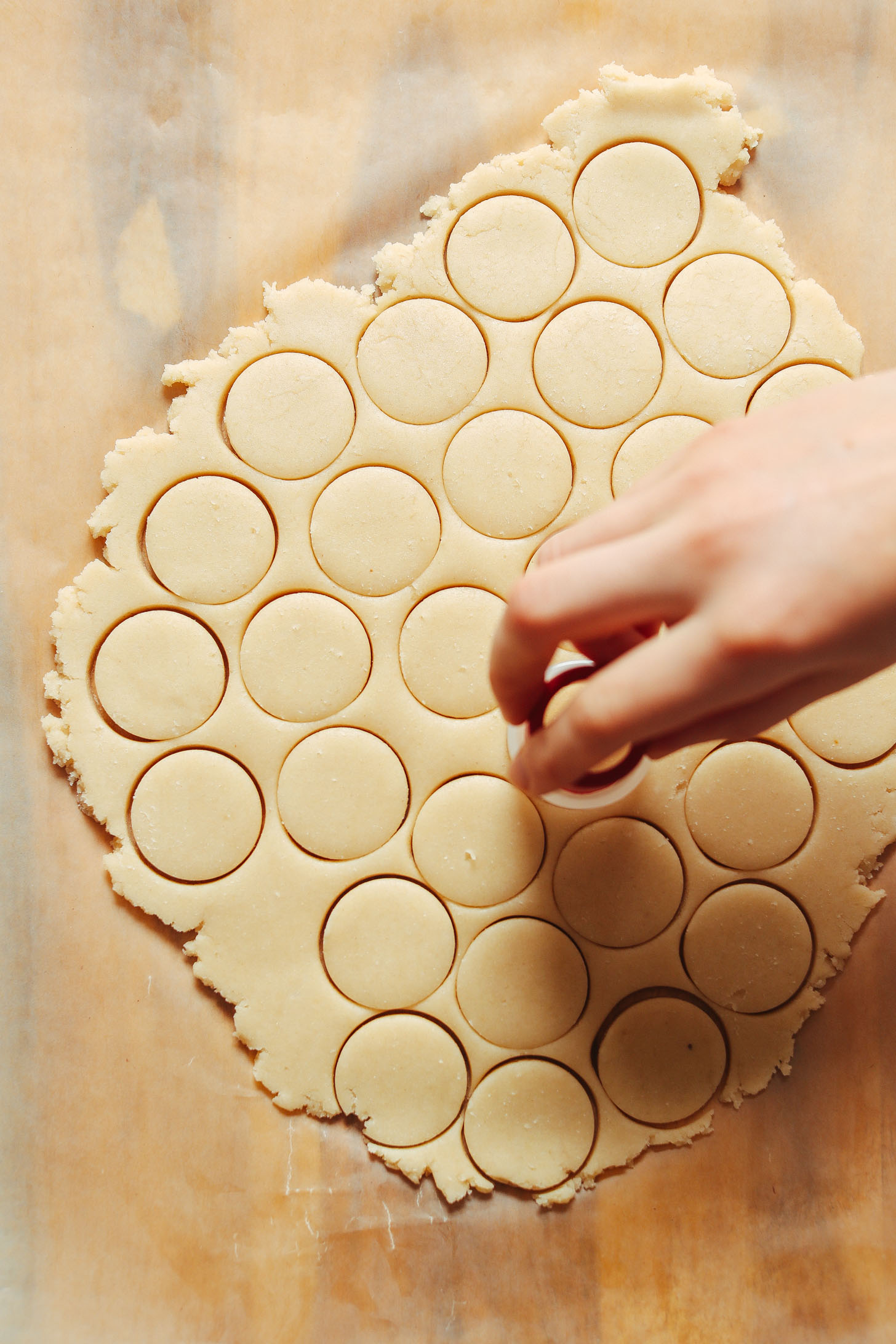 Using a small round cookie cutter to create vanilla wafers shapes