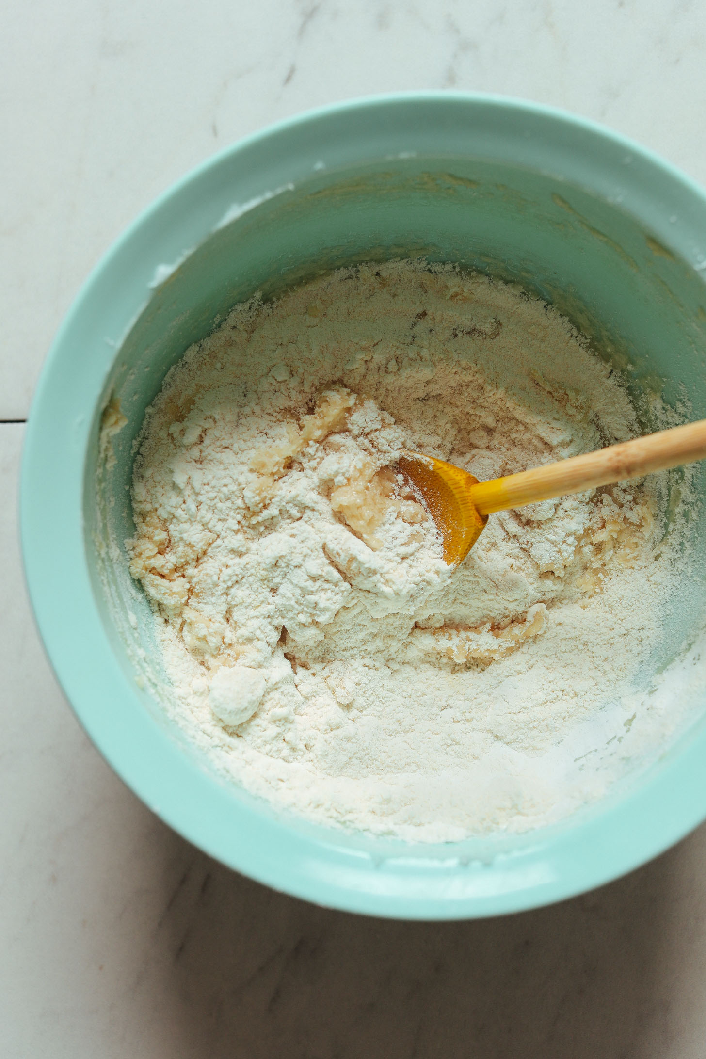 Mixing gluten-free flour into wet ingredients for easy homemade gluten-free Vanilla Wafers