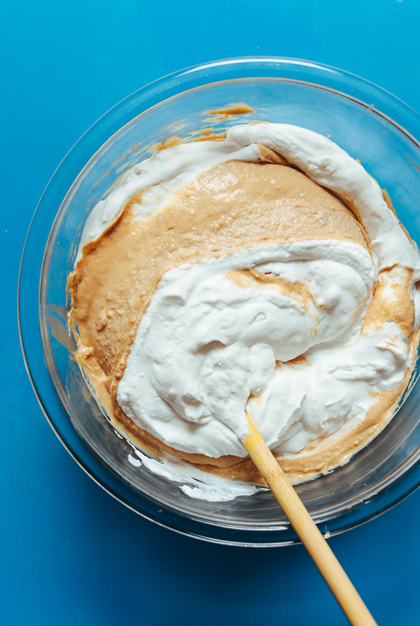 Folding half of the vegan coconut whipped cream into the peanut butter pudding