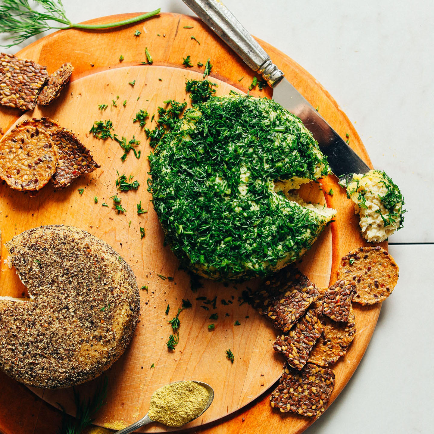 Cultured Vegan Cheese Wheels on a wood cutting board