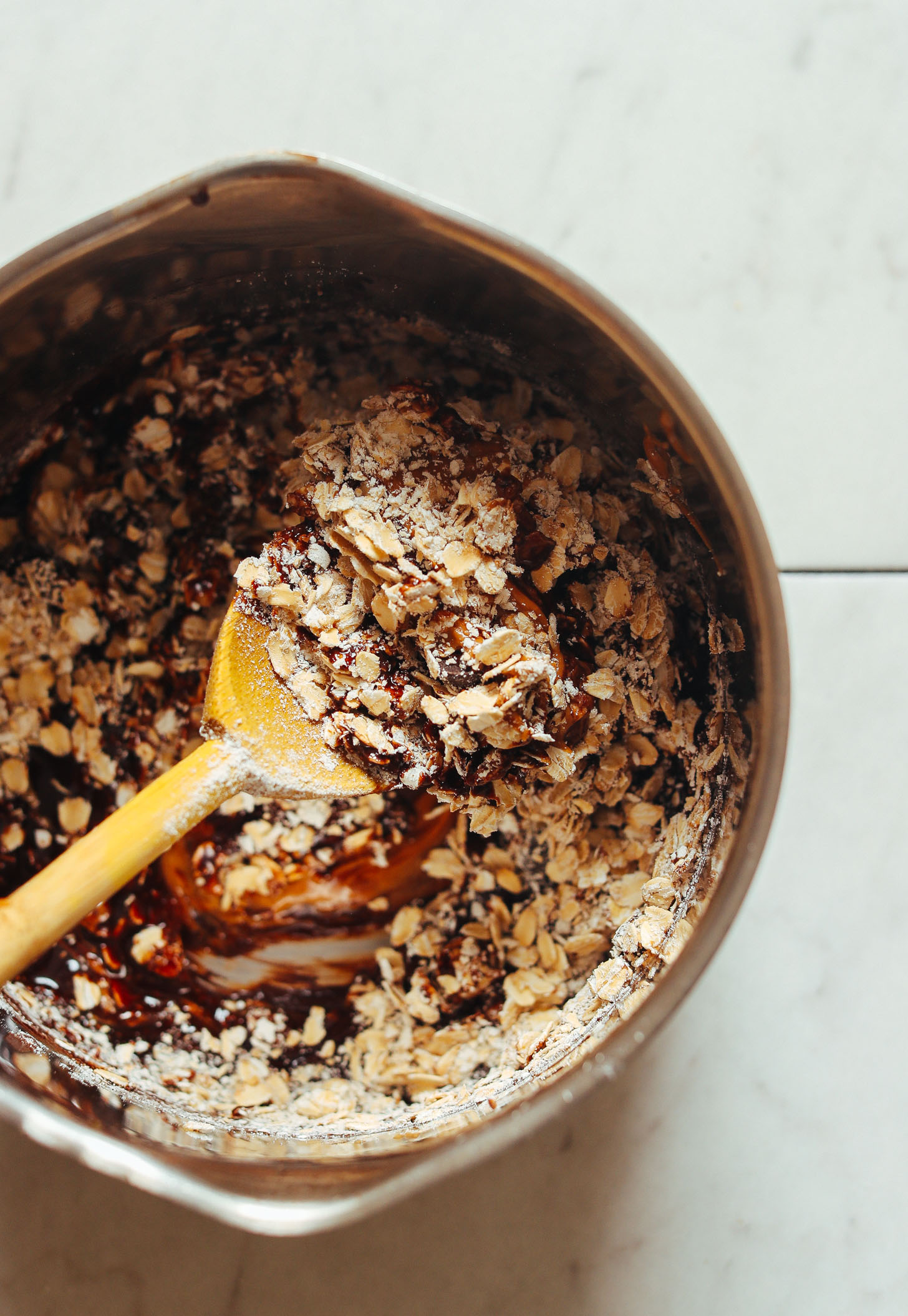 Stirring oats into a saucepan of other ingredients for Vegan Peanut Butter No Bake Cookies