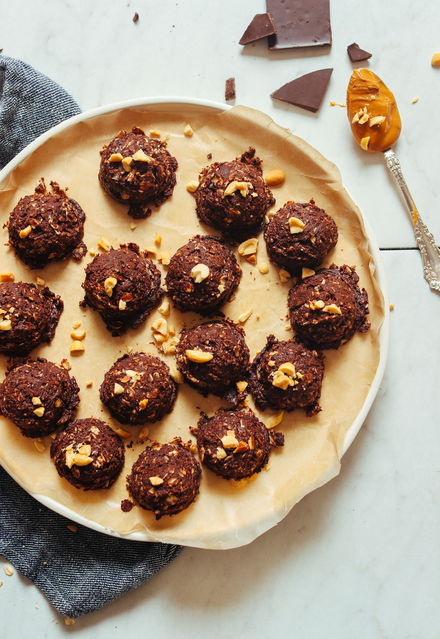 Parchment-lined plate with a batch of our delicious No Bake Peanut Butter Cookies recipe for a vegan dessert