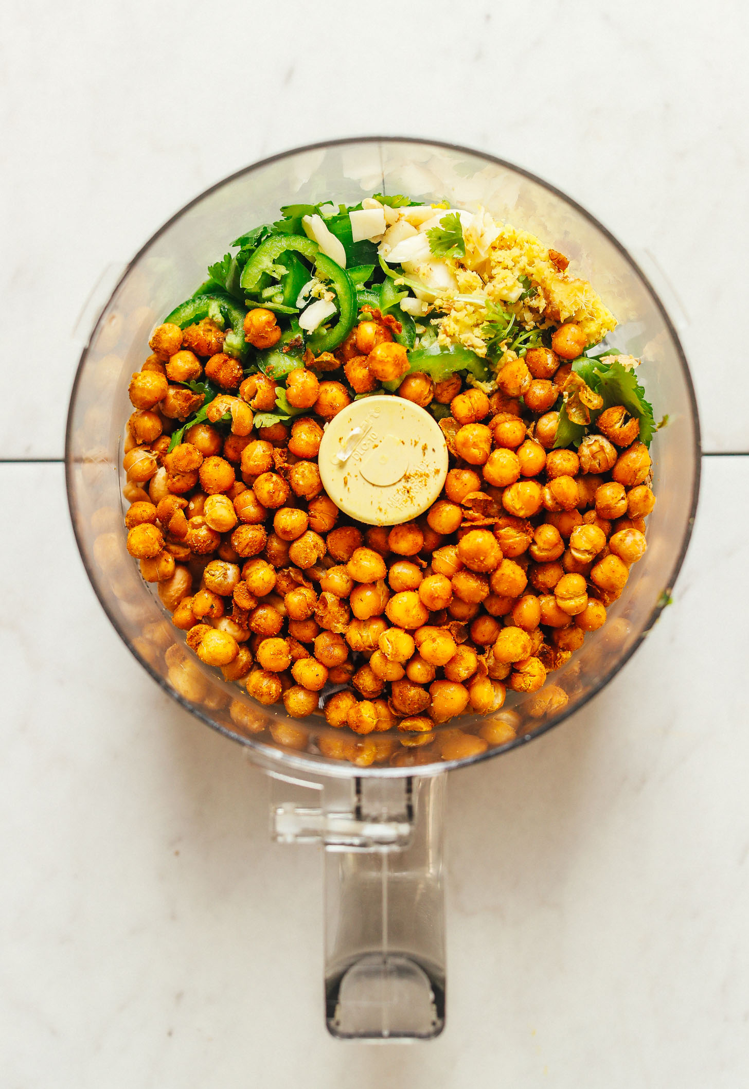 Food processor filled with ingredients for making our gluten-free vegan Curried Chickpea Burgers recipe