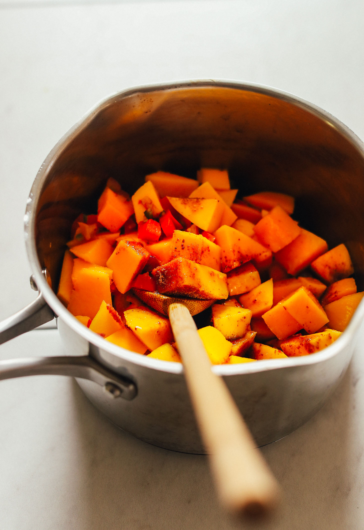 Stirring mango and spices in a saucepan for homemade Spicy Mango Chutney