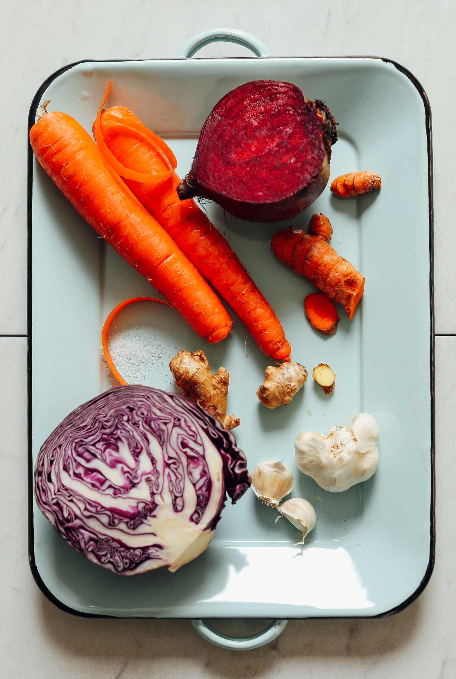Tray of red cabbage, garlic, ginger, turmeric, carrots, and beets