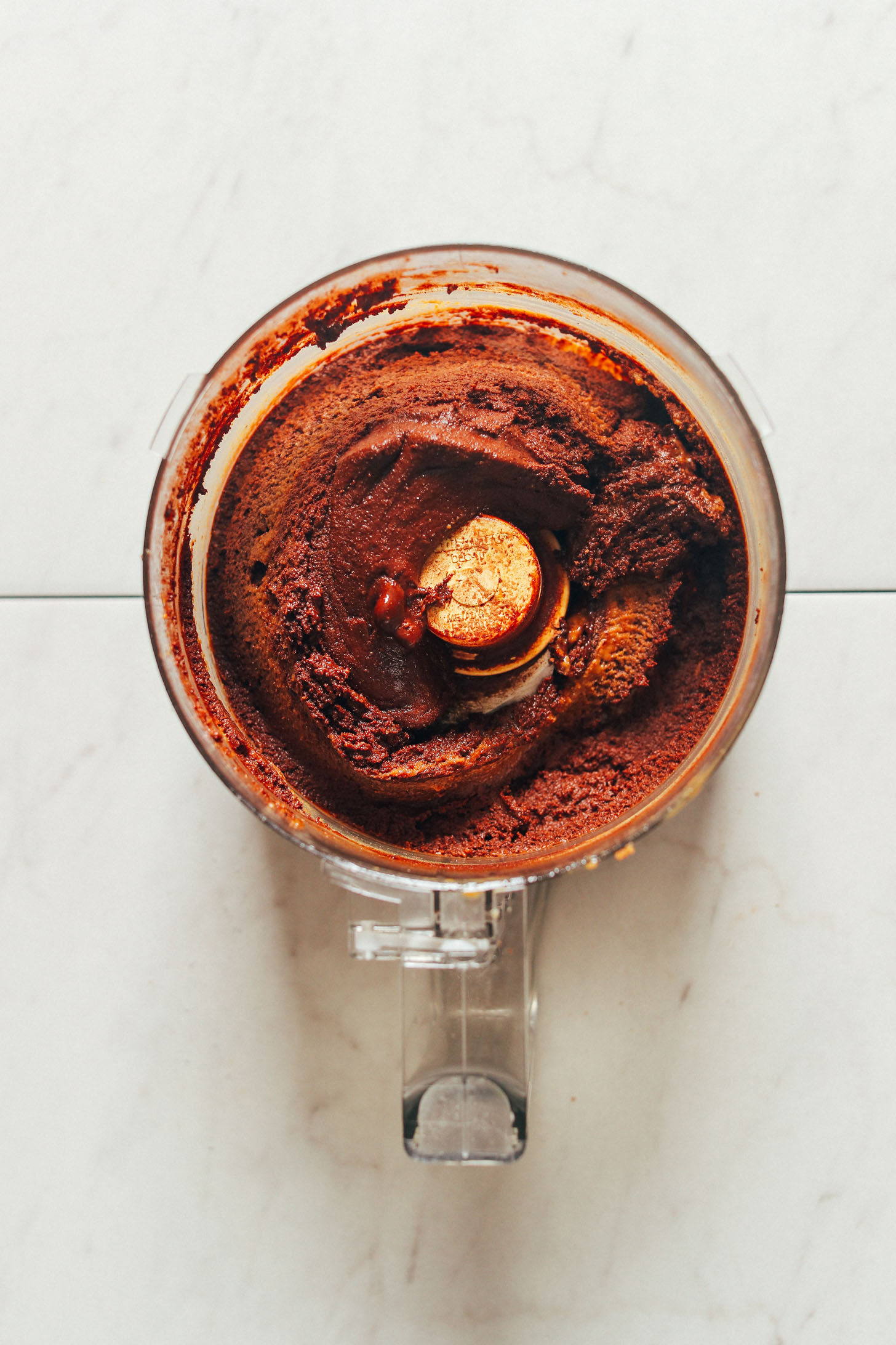 Food processor with freshly blended chocolatey vegan fudge