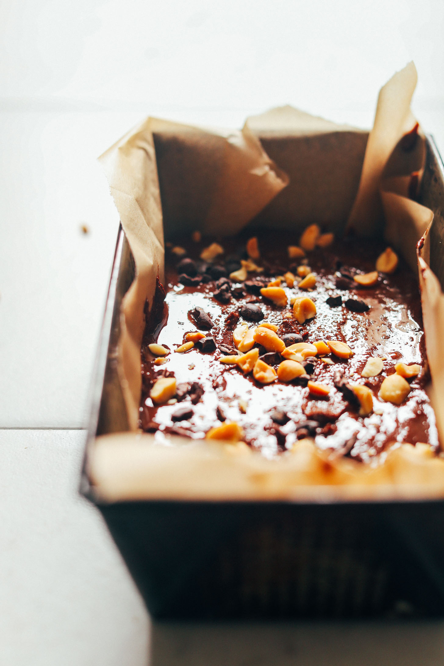 Parchment-lined baking pan with gluten-free Vegan Chocolate Peanut Butter Fudge