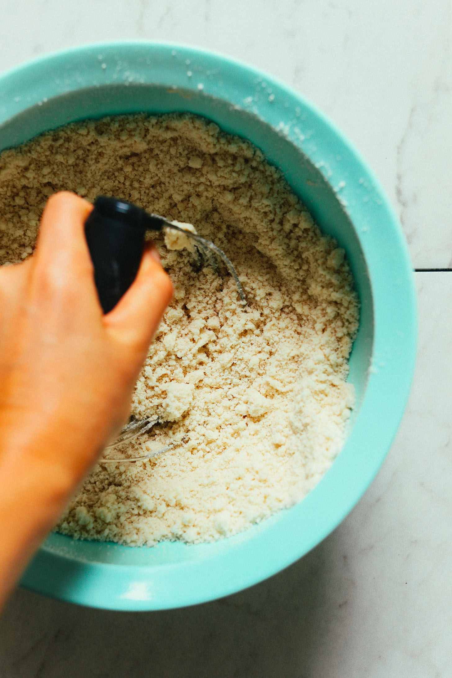 Using a pastry cutter to mix cinnamon roll ingredients