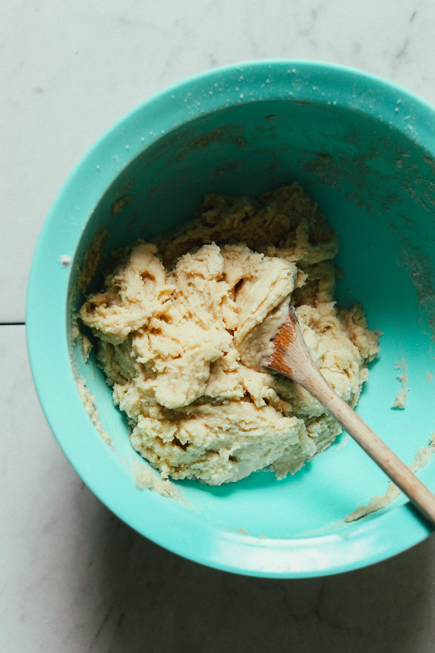 Using a wooden spoon to stir Vegan Gluten-Free Cinnamon Roll batter