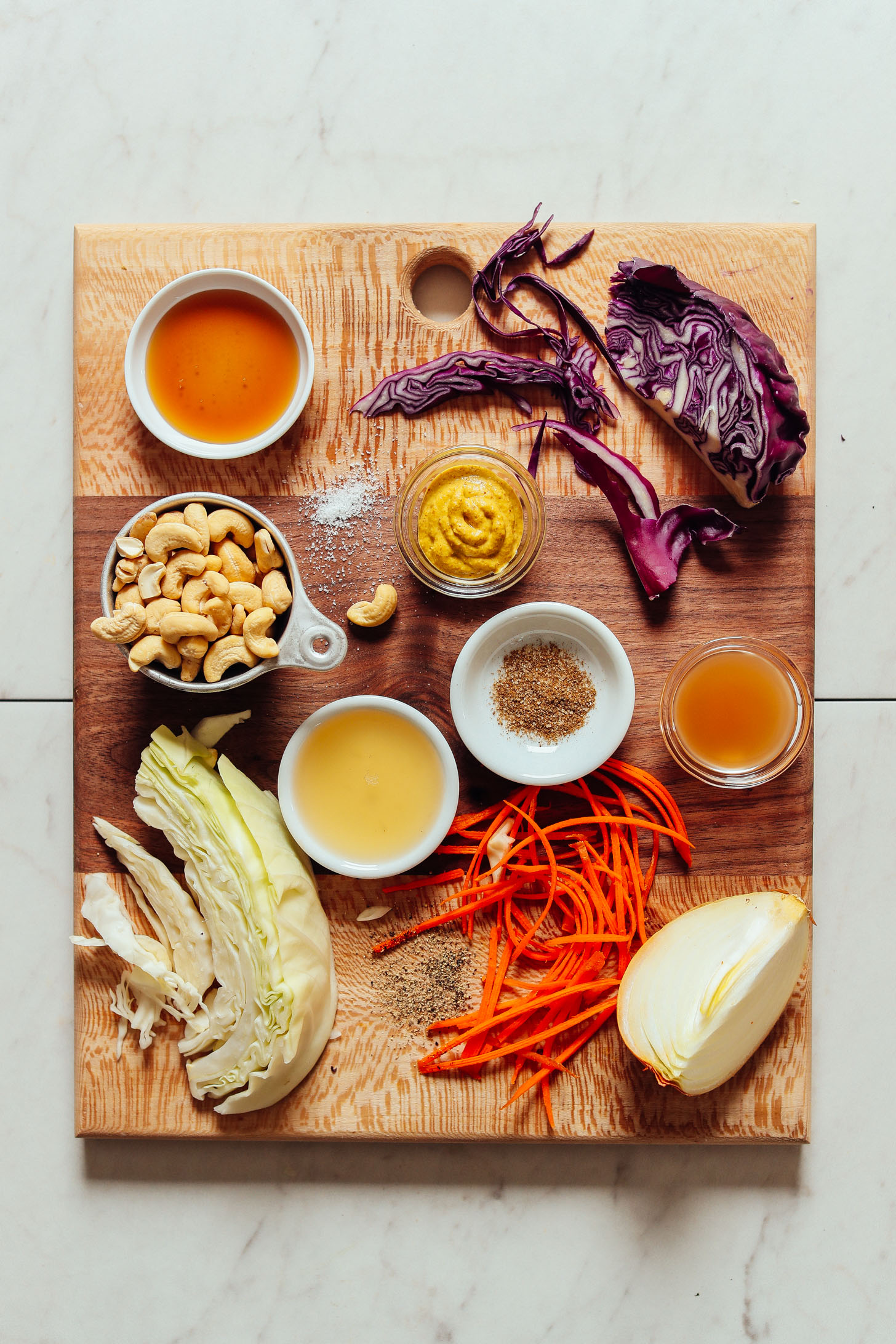 Cutting board filled with ingredients for making our healthy homemade vegan coleslaw recipe