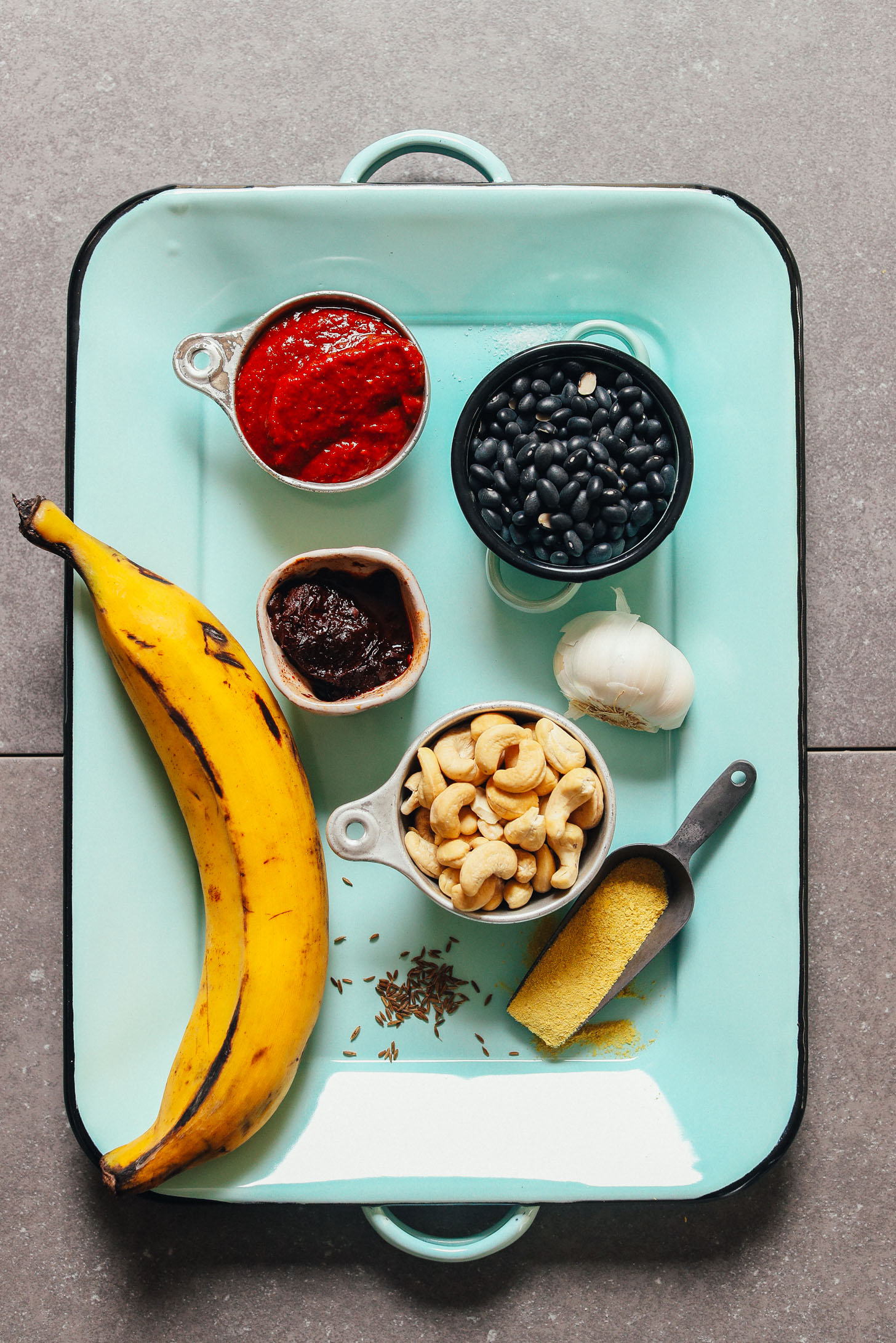 Tray with ingredients for making our vegan Plantain Black Bean Enchilada Bake recipe