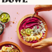 Two Dragon Fruit Smoothie Bowls topped with fresh fruit, coconut, and granola