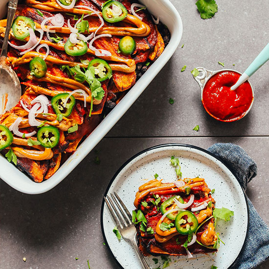 Plate and baking dish filled with our Plantain Black Bean Enchilada Bake recipe