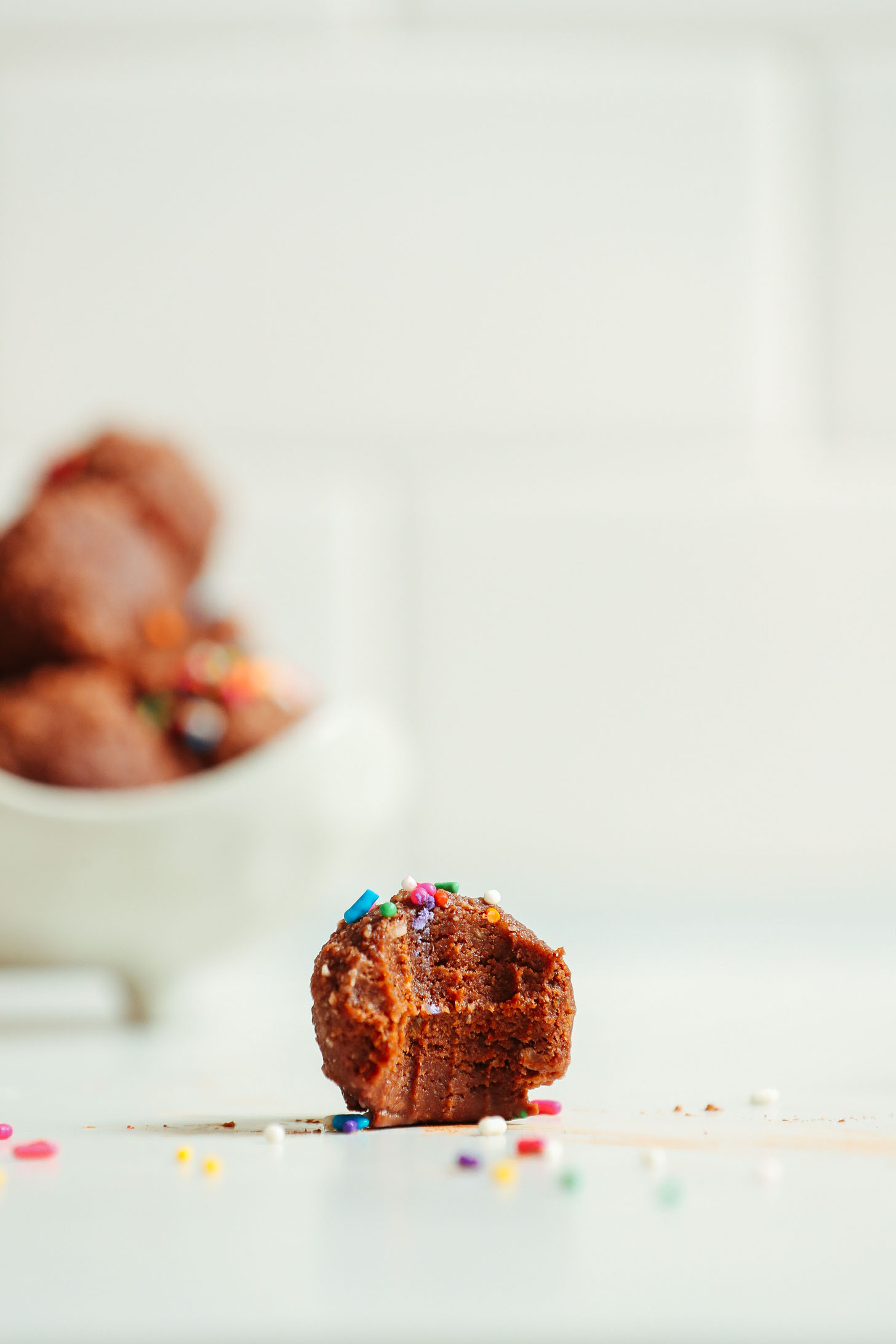 Half eaten fudgy Vegan Chocolate Cake Bite topped with sprinkles