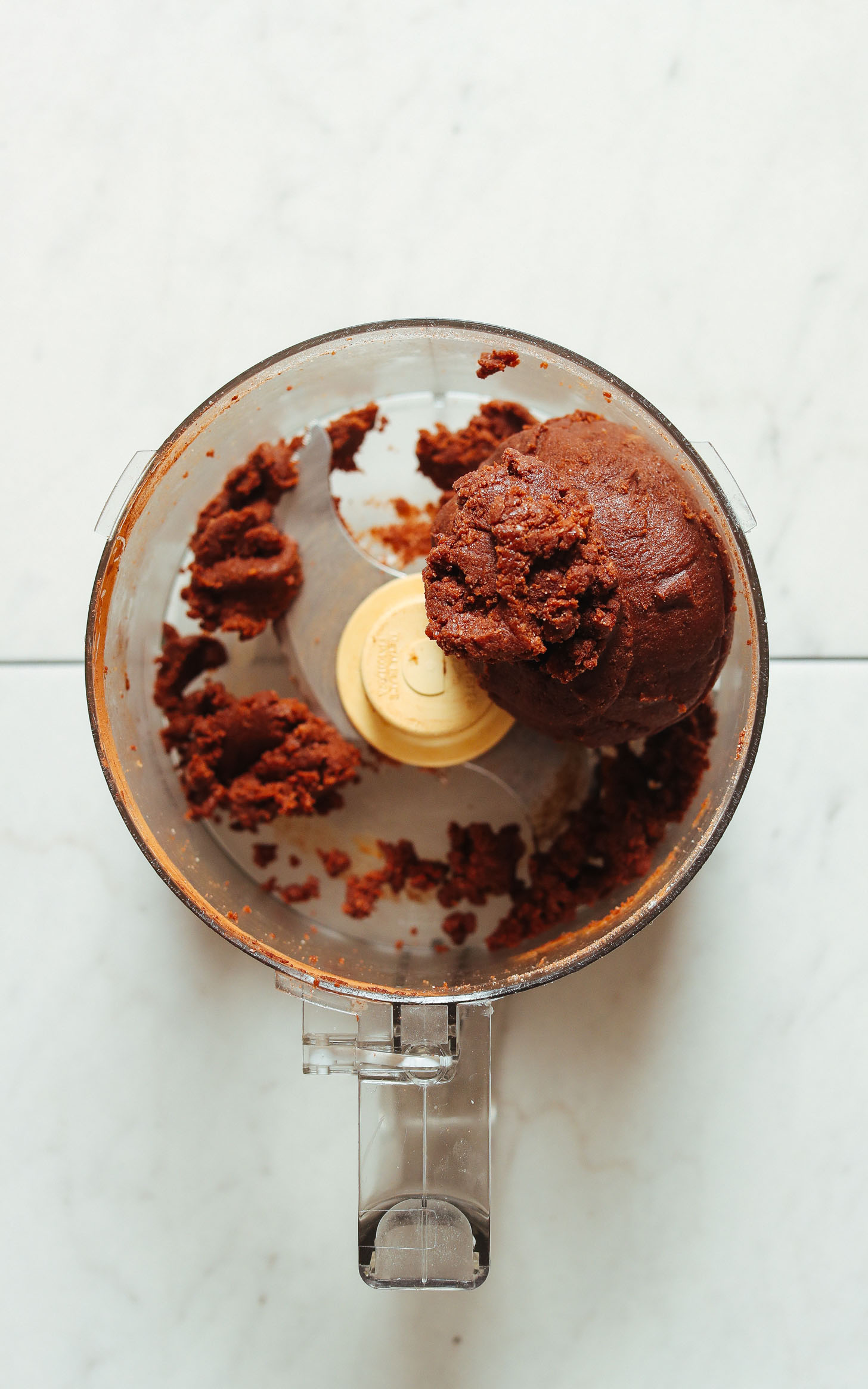 Displaying the fudgy texture of Vegan Chocolate Cake Bites batter in the food processor
