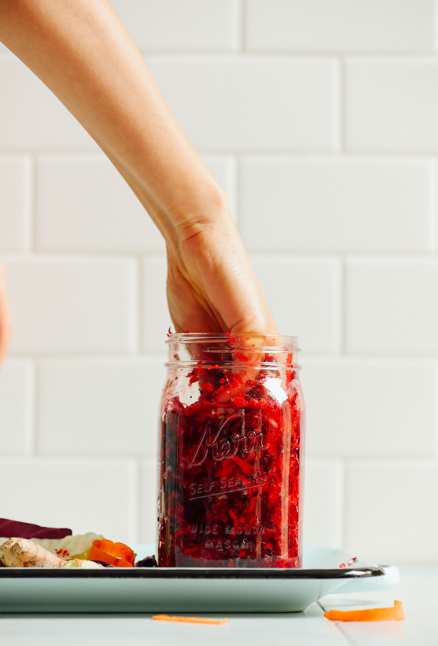 Pressing down on the vegetables inside a jar of sauerkraut