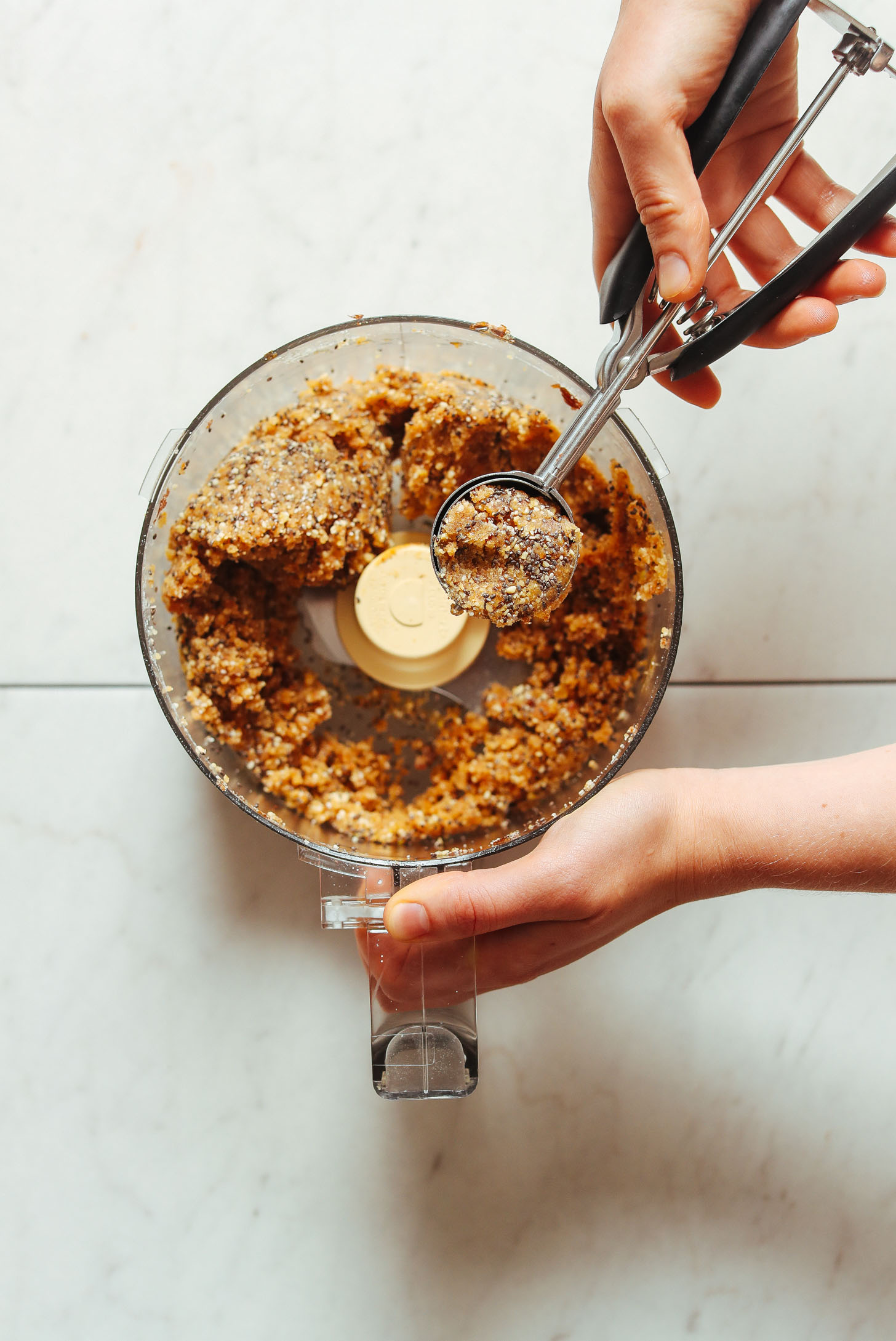 Using a small ice cream scooper to form homemade Vegan Lemon Poppy Seed Donut Holes