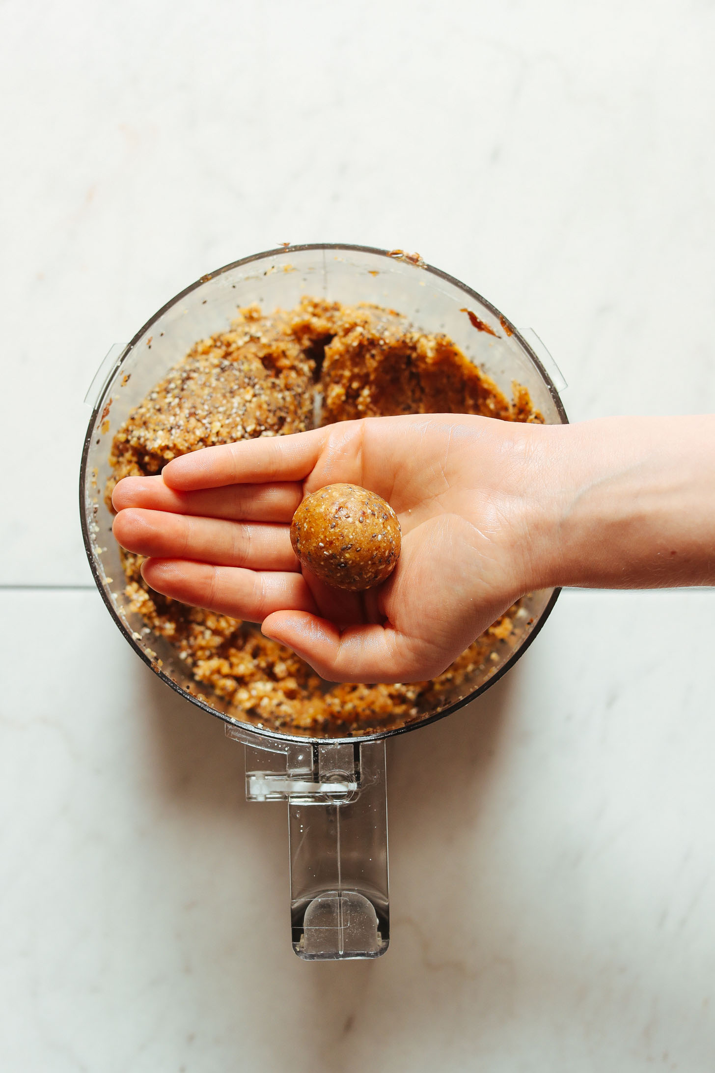 Holding one of our freshly rolled Vegan Lemon Poppy Seed Donut Holes