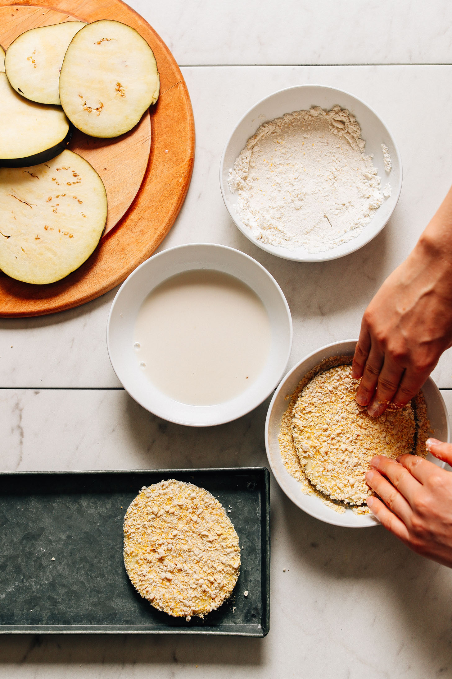 Coating sliced eggplant in batter for making crispy Mini Eggplant Pizzas