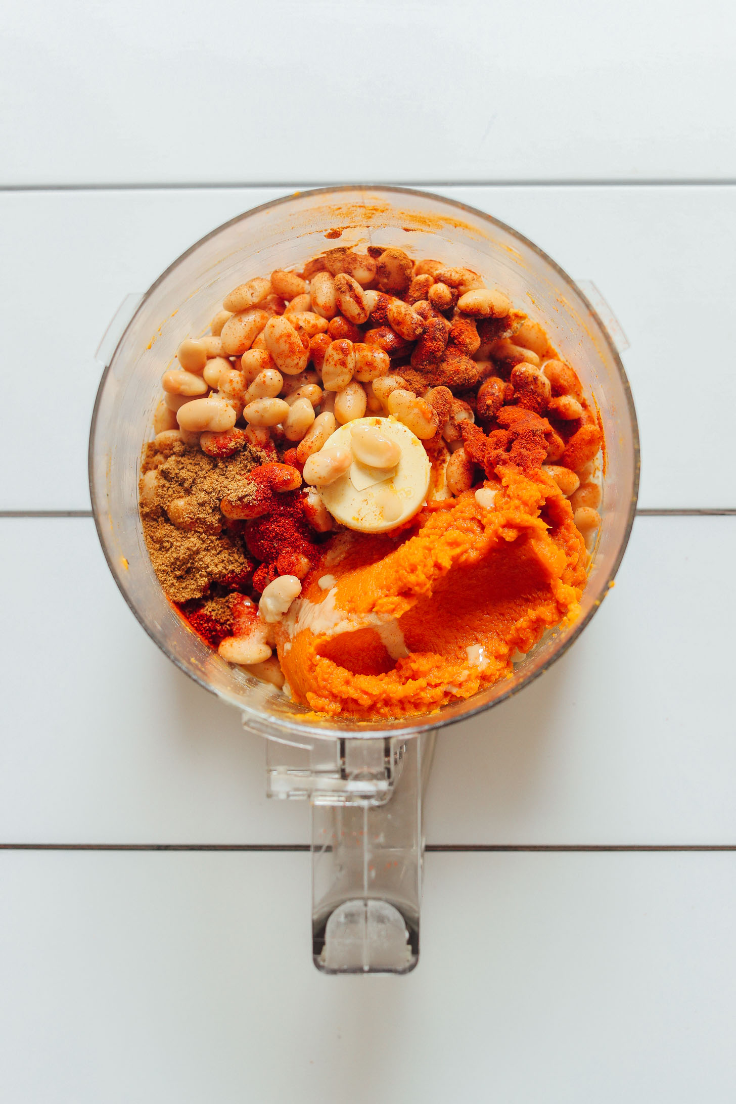 Food processor with ingredients for making our gluten-free vegan White Bean Pumpkin Hummus recipe