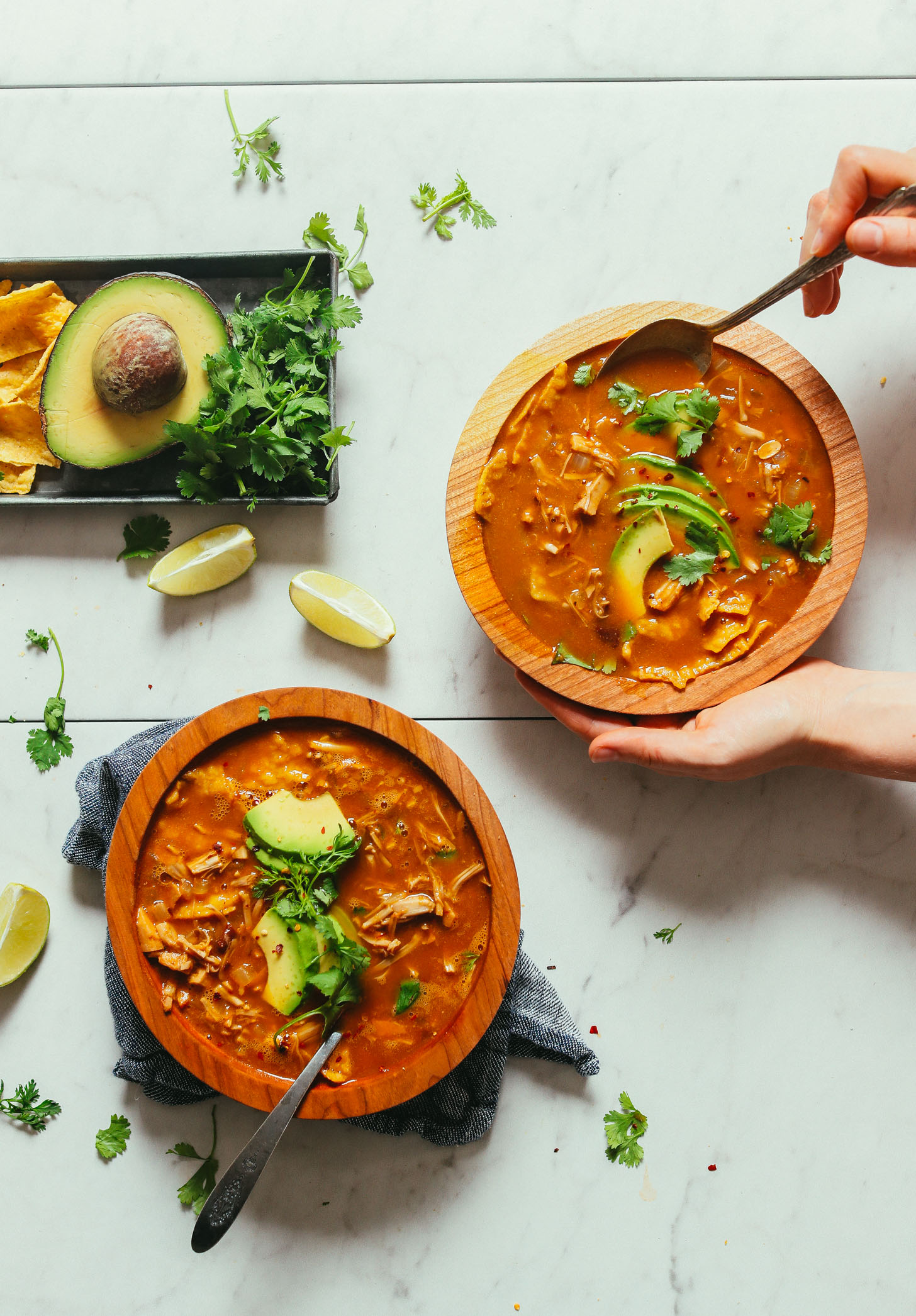 Grabbing a spoonful of Vegan Jackfruit Tortilla Soup topped with avocado and cilantro