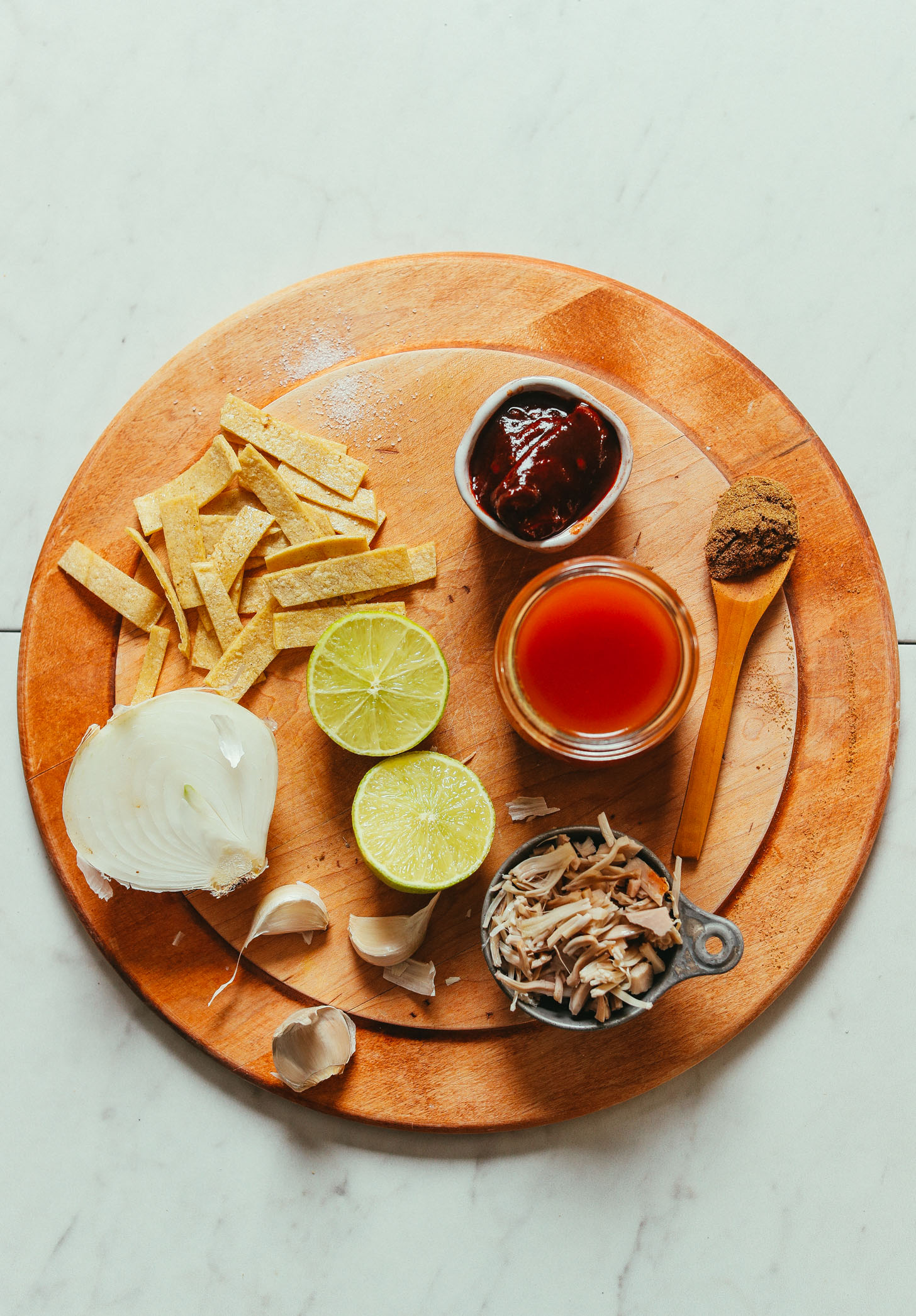 Wood cutting board filled with ingredients for making our Vegan Jackfruit Tortilla Soup recipe