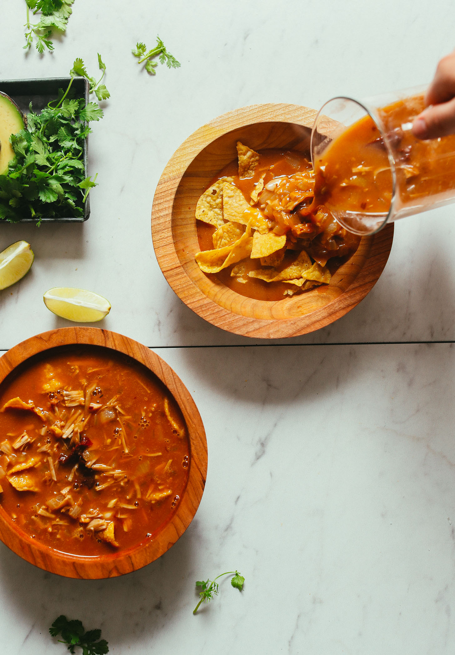 Pouring soup over tortilla chips for Vegan Tortilla Soup with Jacfruit