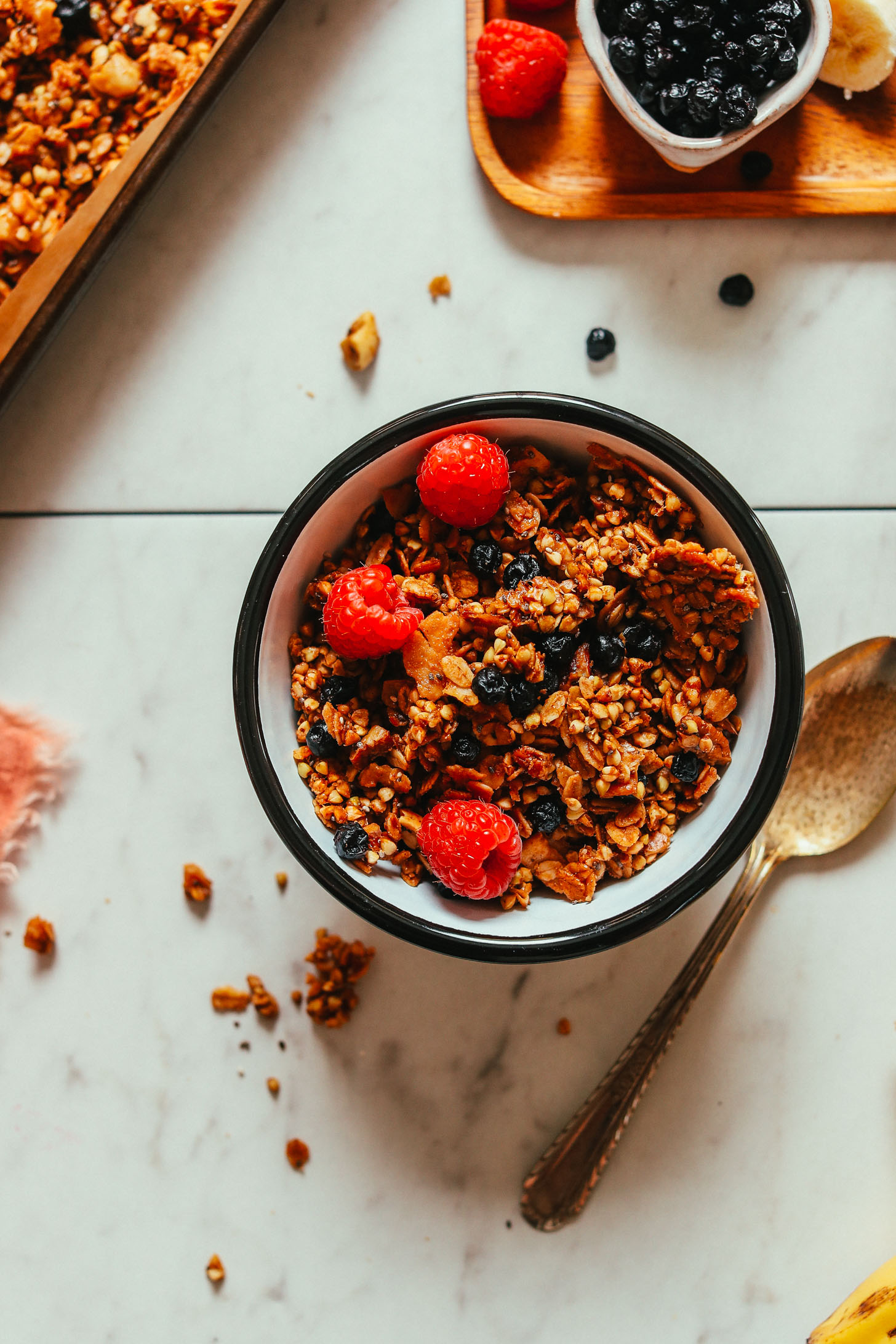 Close up overhead shot of a bowl of our delicious Easy Buckwheat Granola with fresh raspberries and dried blueberries