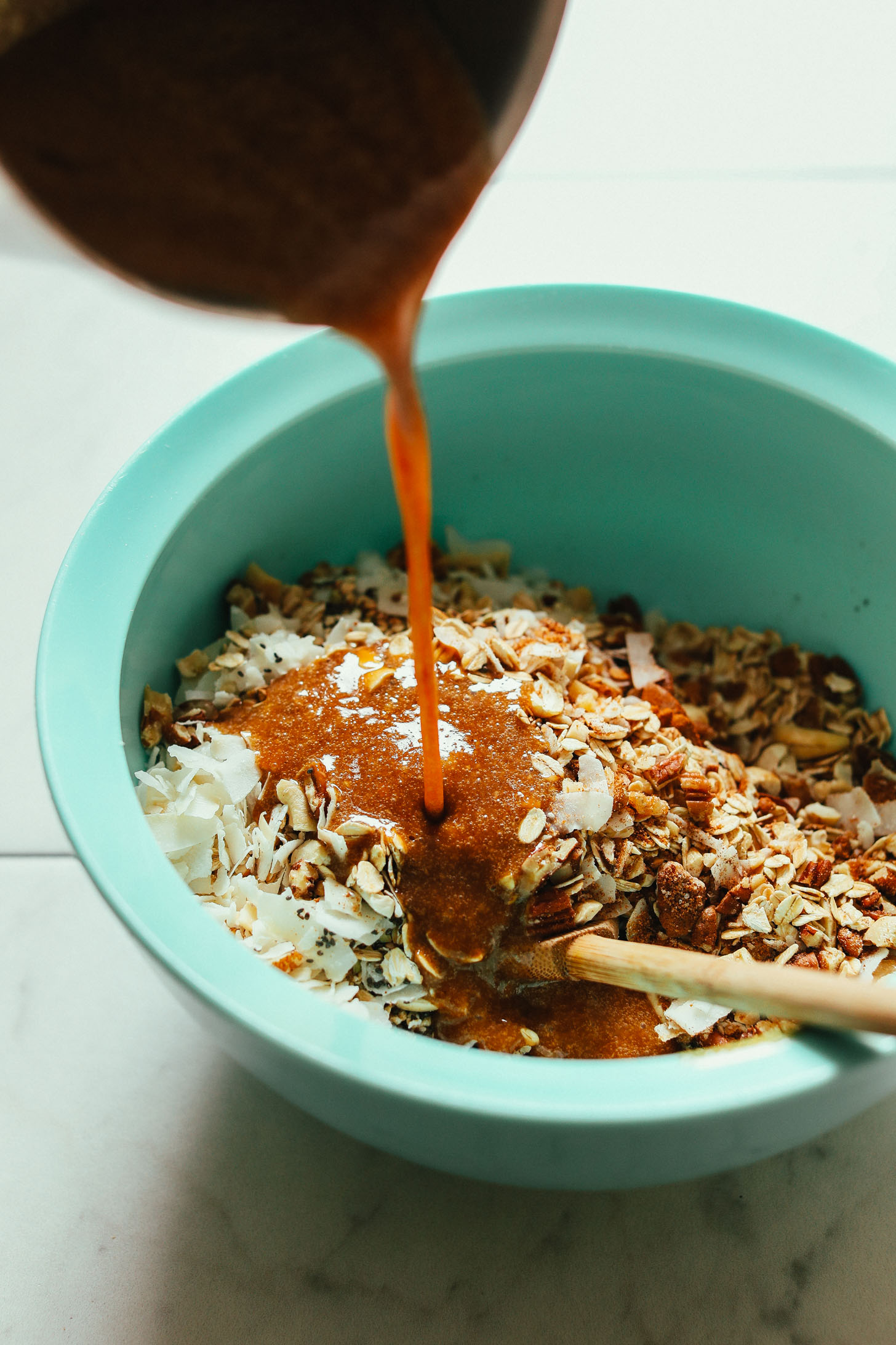 Pouring wet ingredients into dry for our gluten-free vegan Easy Buckwheat Granola recipe