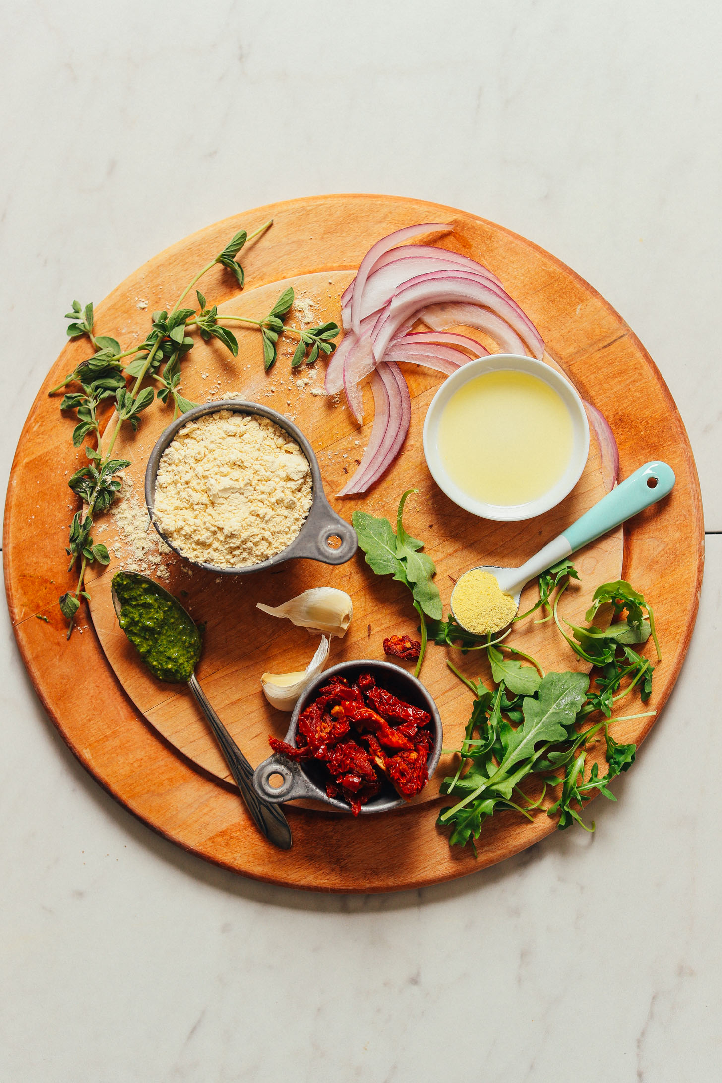 Wood cutting board filled with ingredients for making our Socca Pizza recipe