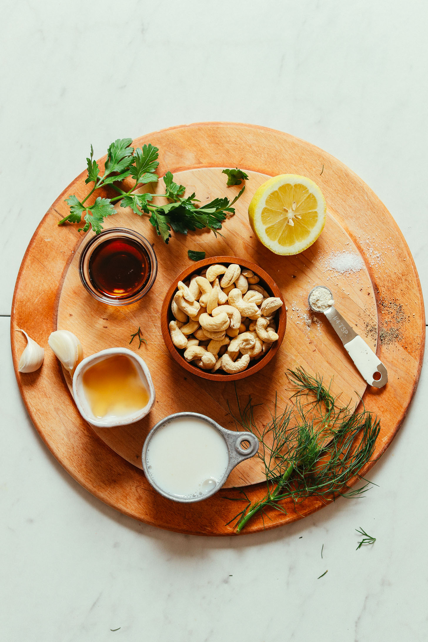 Wood cutting board with ingredients for making our Creamy Vegan Ranch recipe