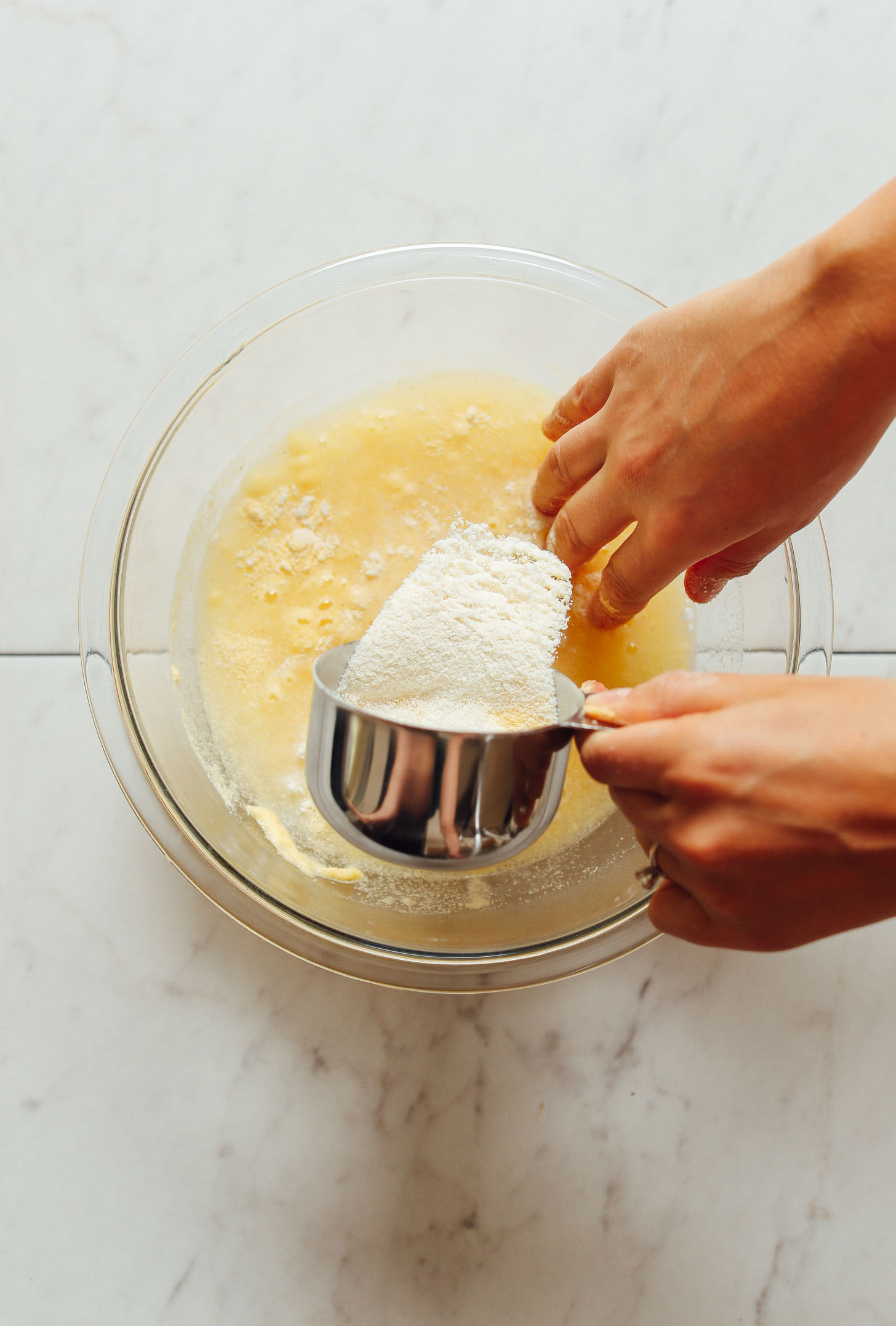 Using fingers to stir areparina into water for homemade Arepas