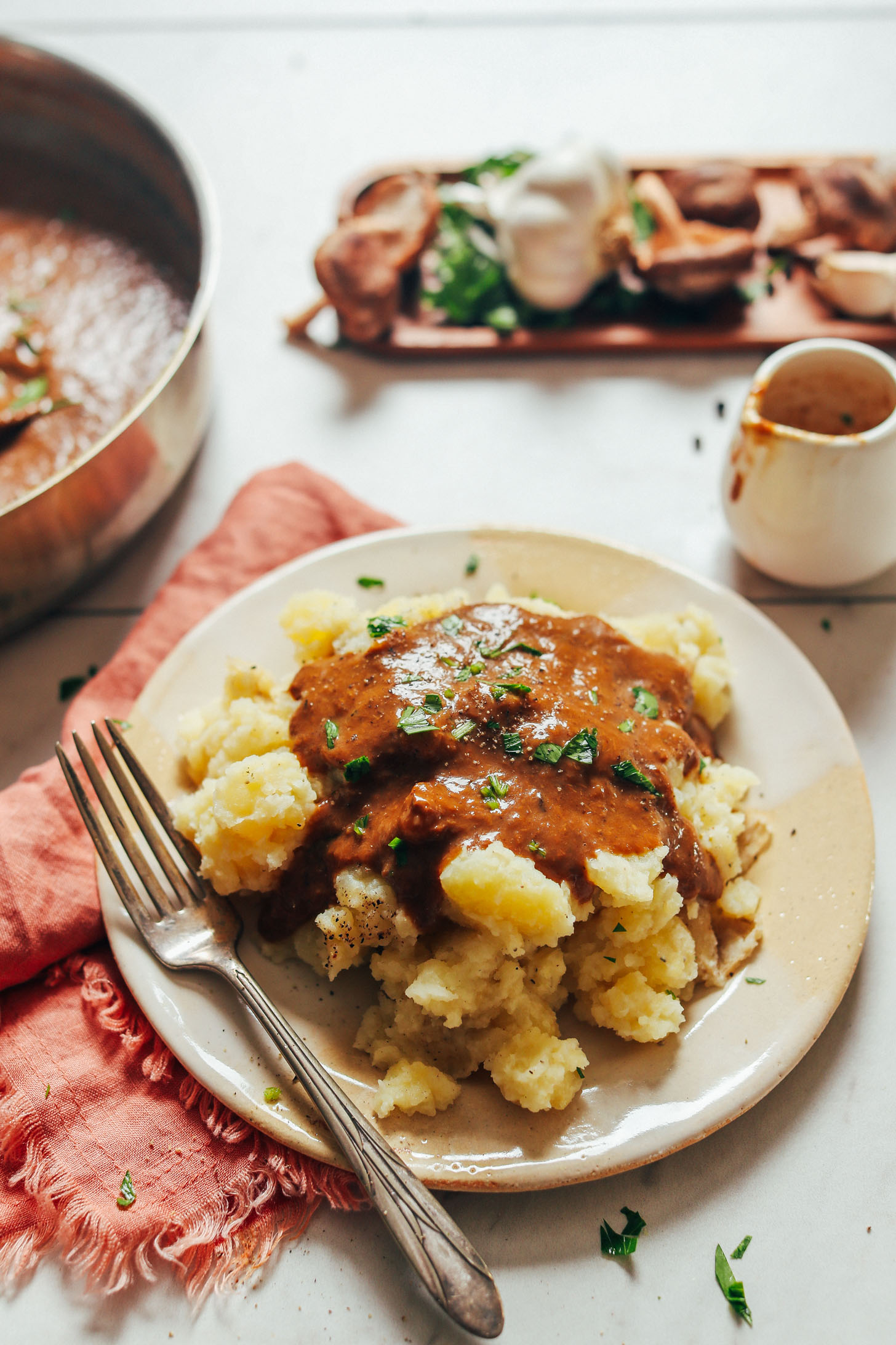 Plate of vegan mashed potatoes and gravy topped with fresh parsley