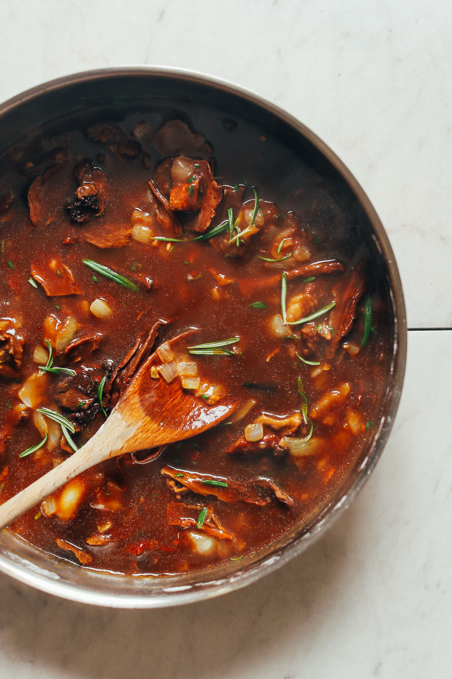 Cooking vegan mushroom gravy made with fresh rosemary