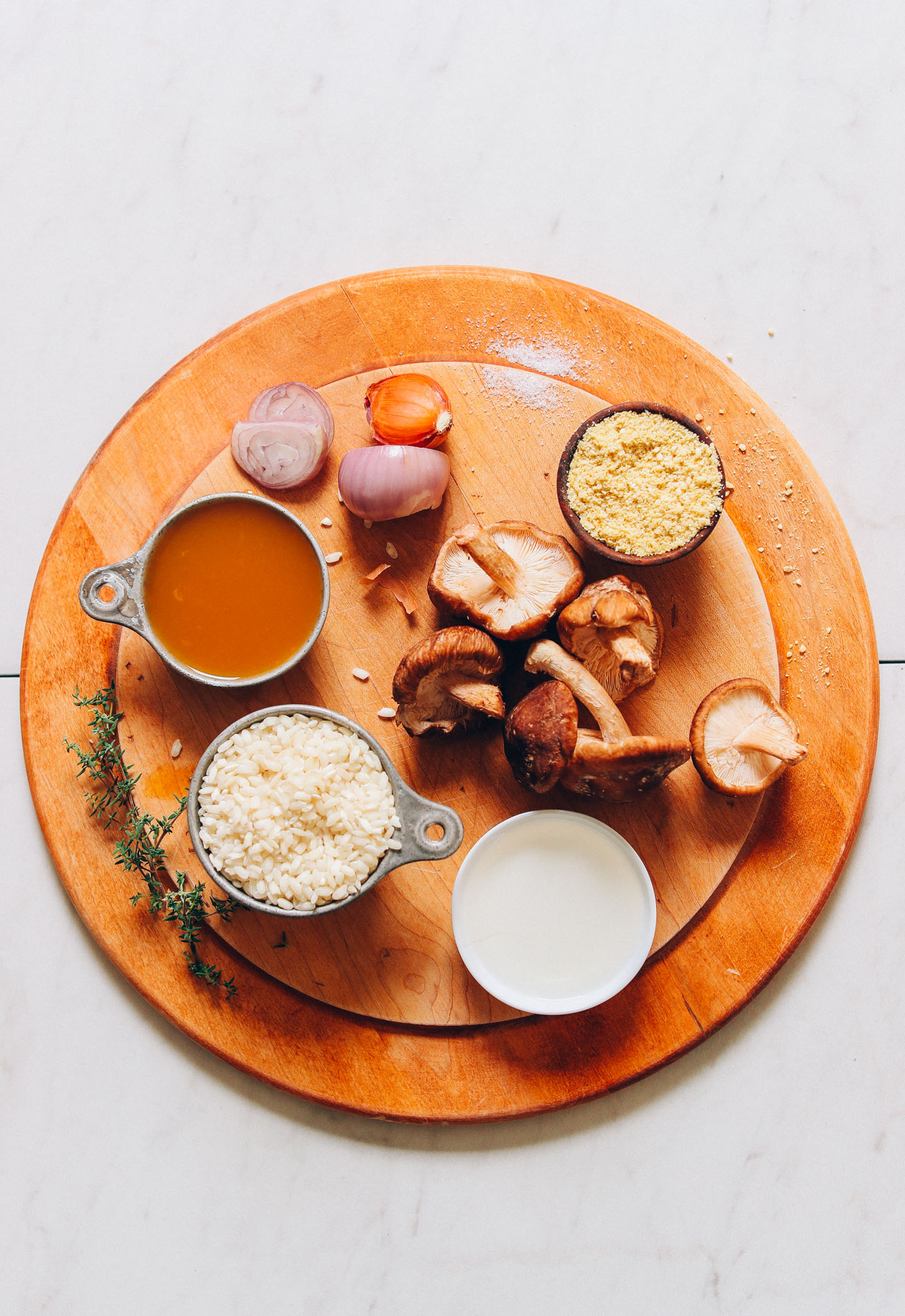 Wood cutting board filled with ingredients for making our Vegan Caramelized Shiitake Mushroom Risotto recipe