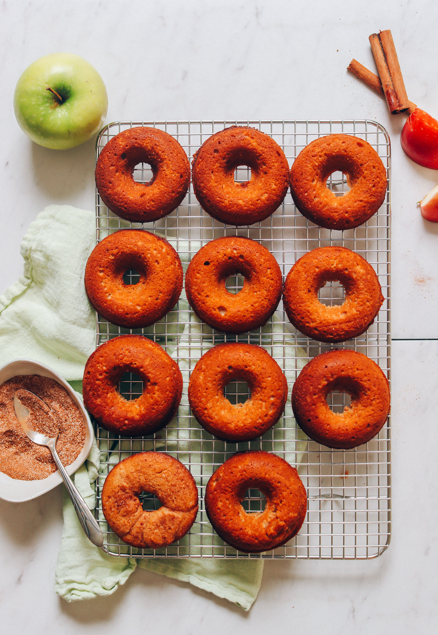 Freshly baked Vegan Gluten-Free Apple Cider Donuts resting on a cooling rack