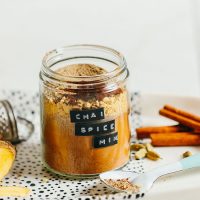 Jar of our simple homemade caffeine-free Chai Mix alongside fresh spices