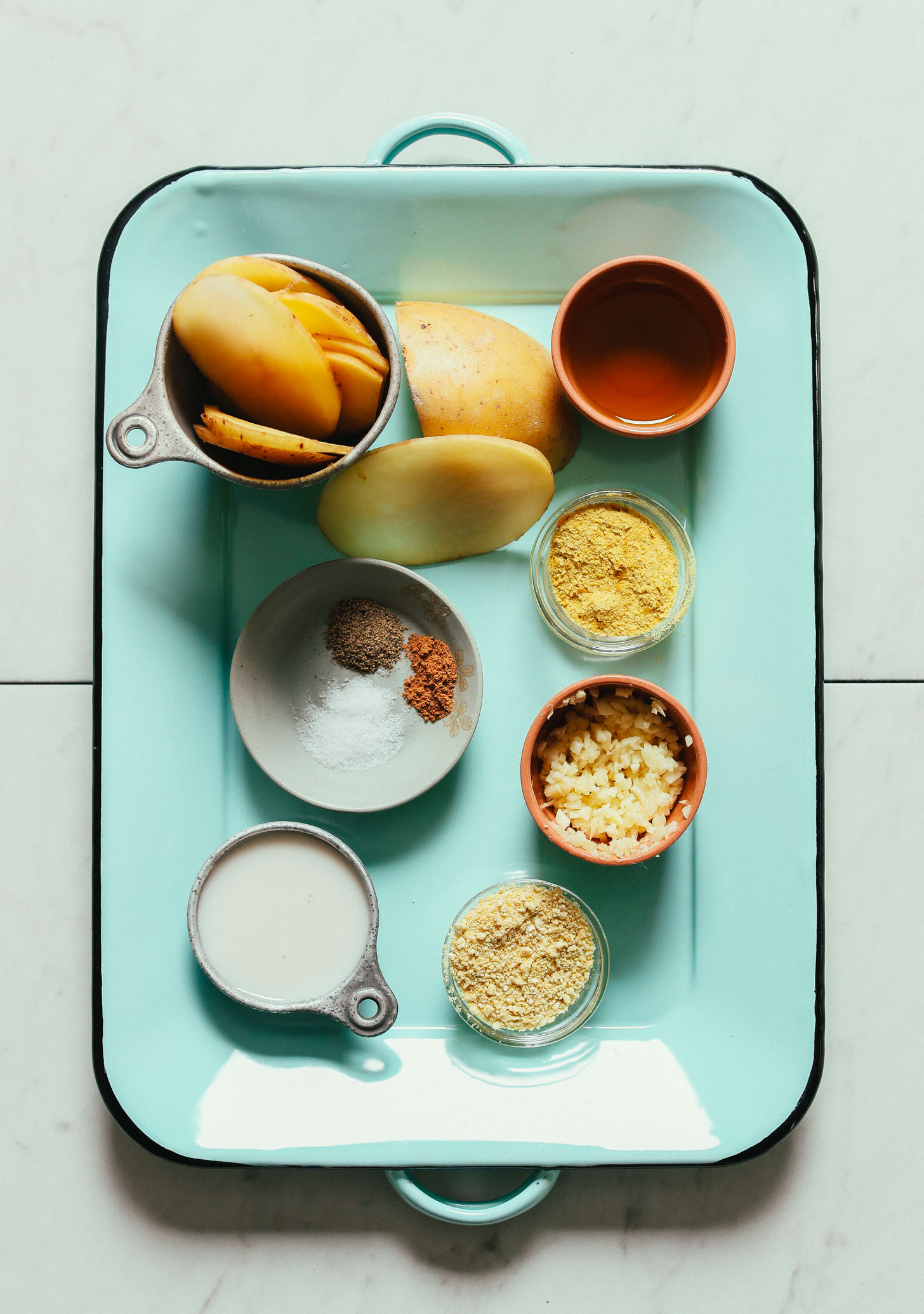 Blue tray with ingredients for making delicious Vegan Scalloped Potatoes