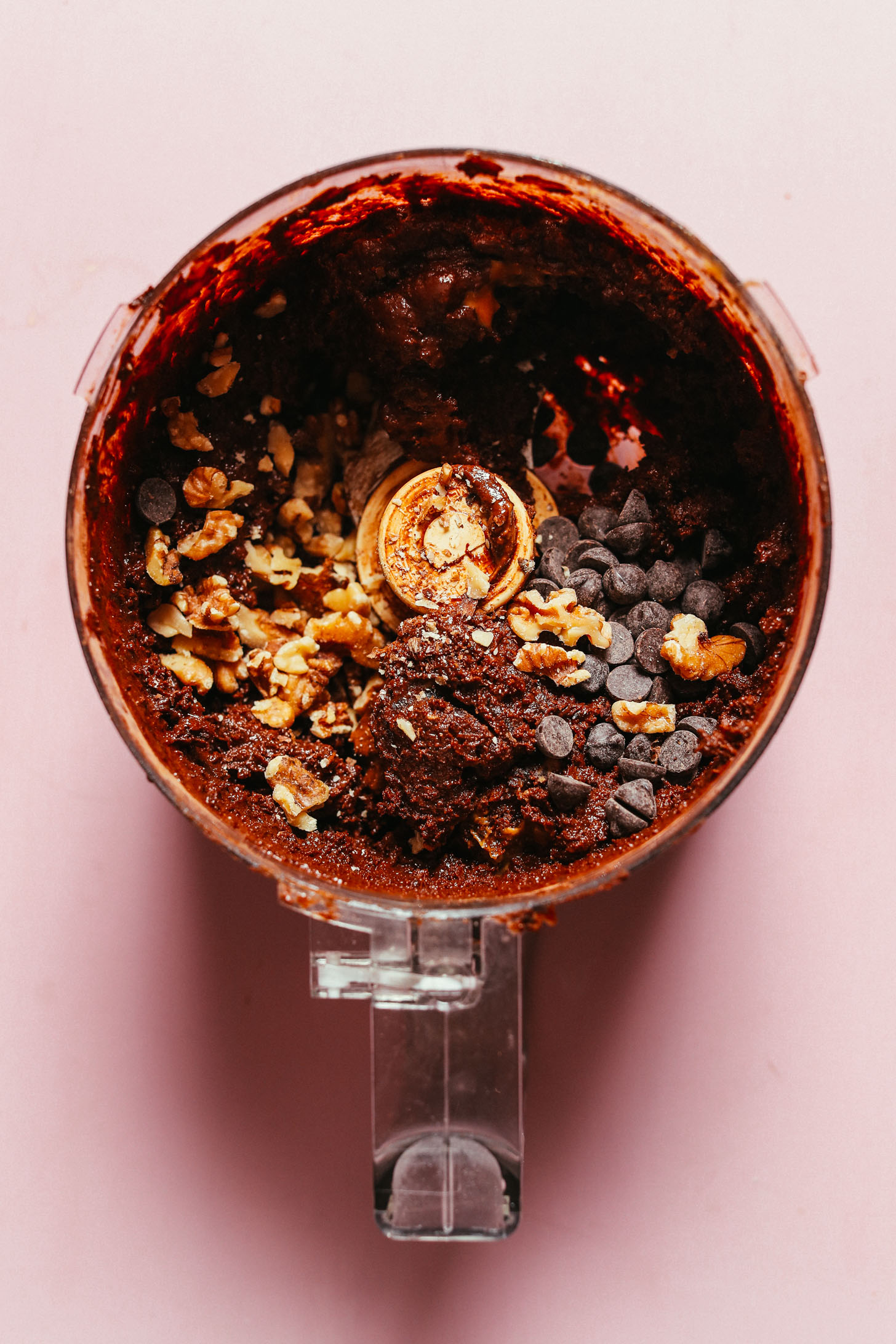 Food processor with vegan brownie batter with chocolate chips and pecans