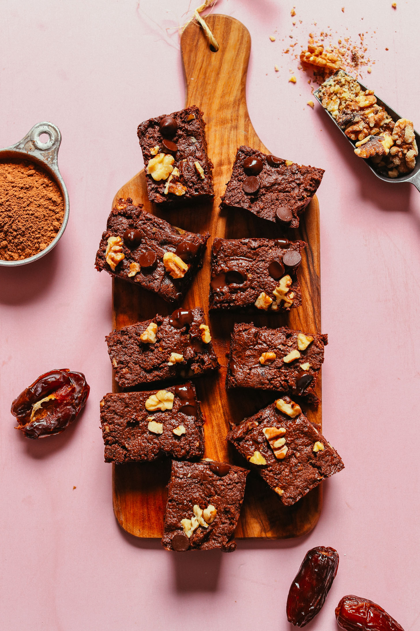 Batch of easy vegan brownies on a wood cutting board alongside ingredients used to make them