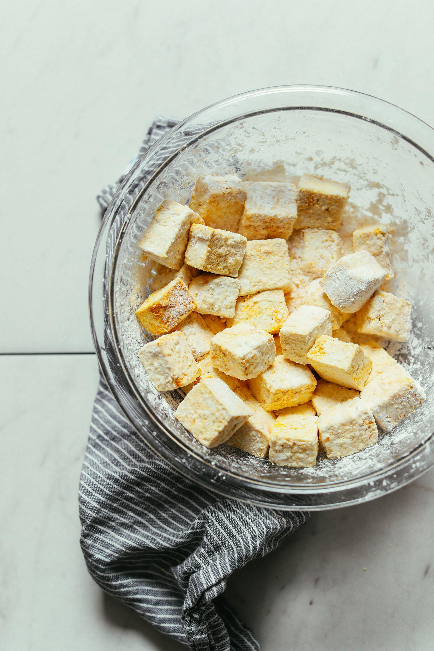 Bowl of marinated cubed tofu tossed in cornstarch